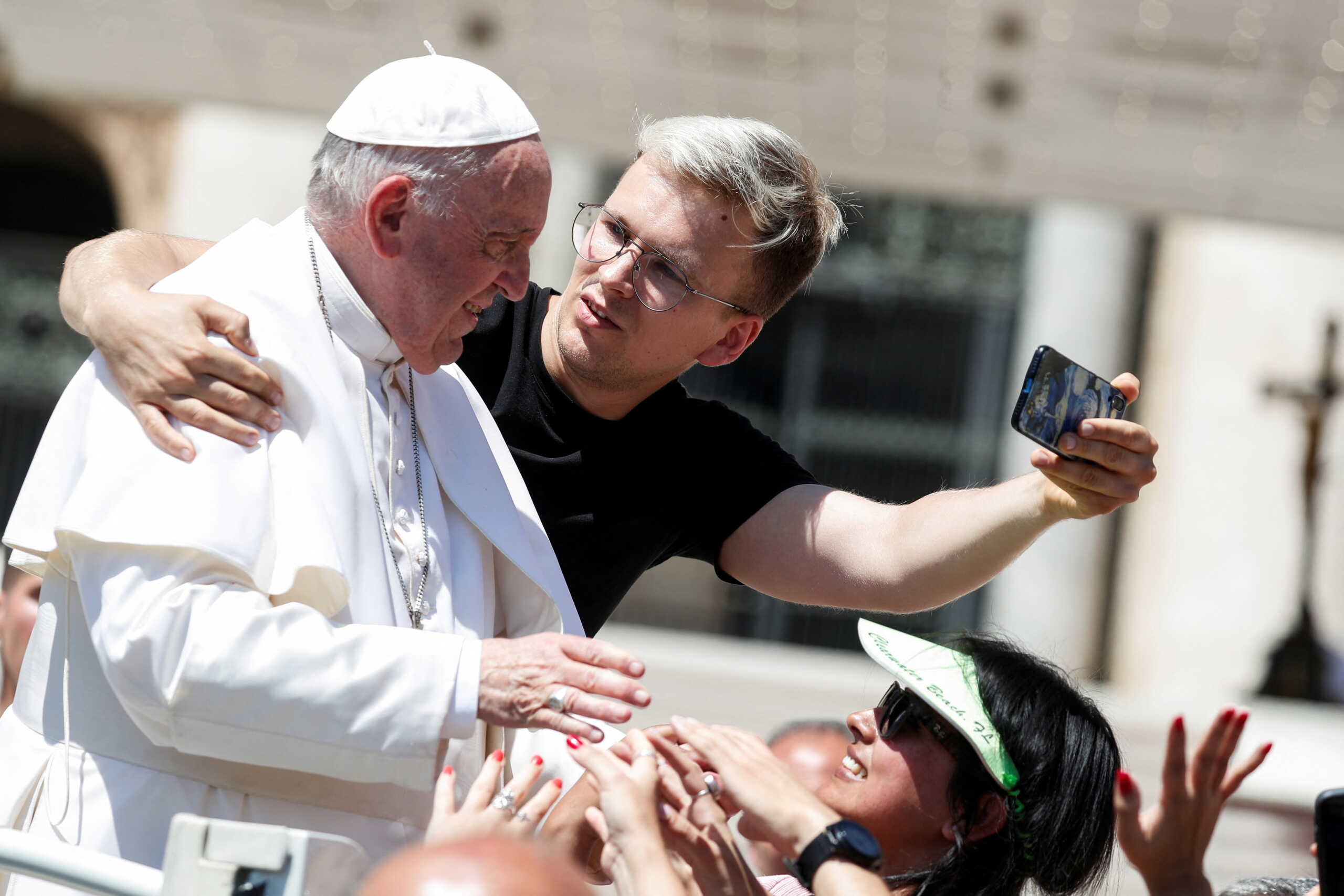 A man takes a selfie with Pope Francis after the weekly general audience at the Vatican, June 8, 2022. REUTERS