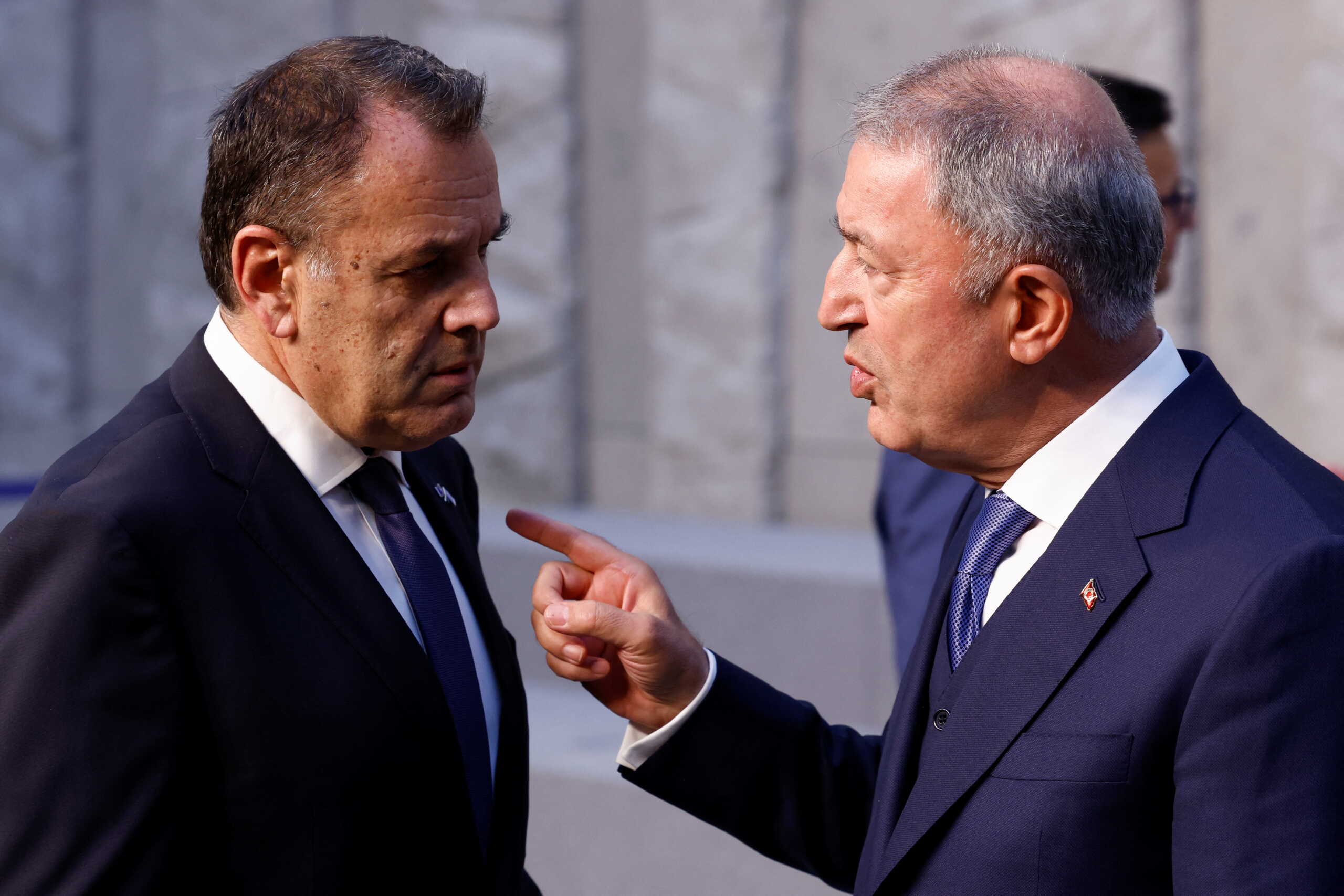 Turkish Defence Minister Hulusi Akar gestures as he talks with Greek Defence Minister Nikolaos Panagiotopoulos after posing for a family photo, during a NATO defence ministers meeting at the Alliance's headquarters in Brussels, Belgium June 16, 2022. REUTERS