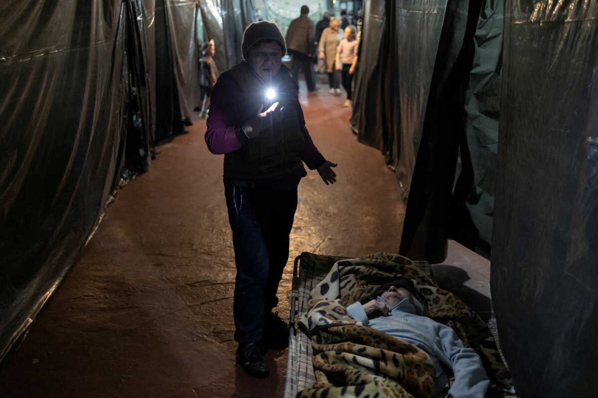 FILE PHOTO: A woman stands above Nadiia Chuhai lying in her bed inside Azot chemical plant's bomb shelter, where people have been hiding from from shelling since the beginning of the war, in Sievierodonetsk, Luhansk region, Ukraine, April 16, 2022. REUTERS