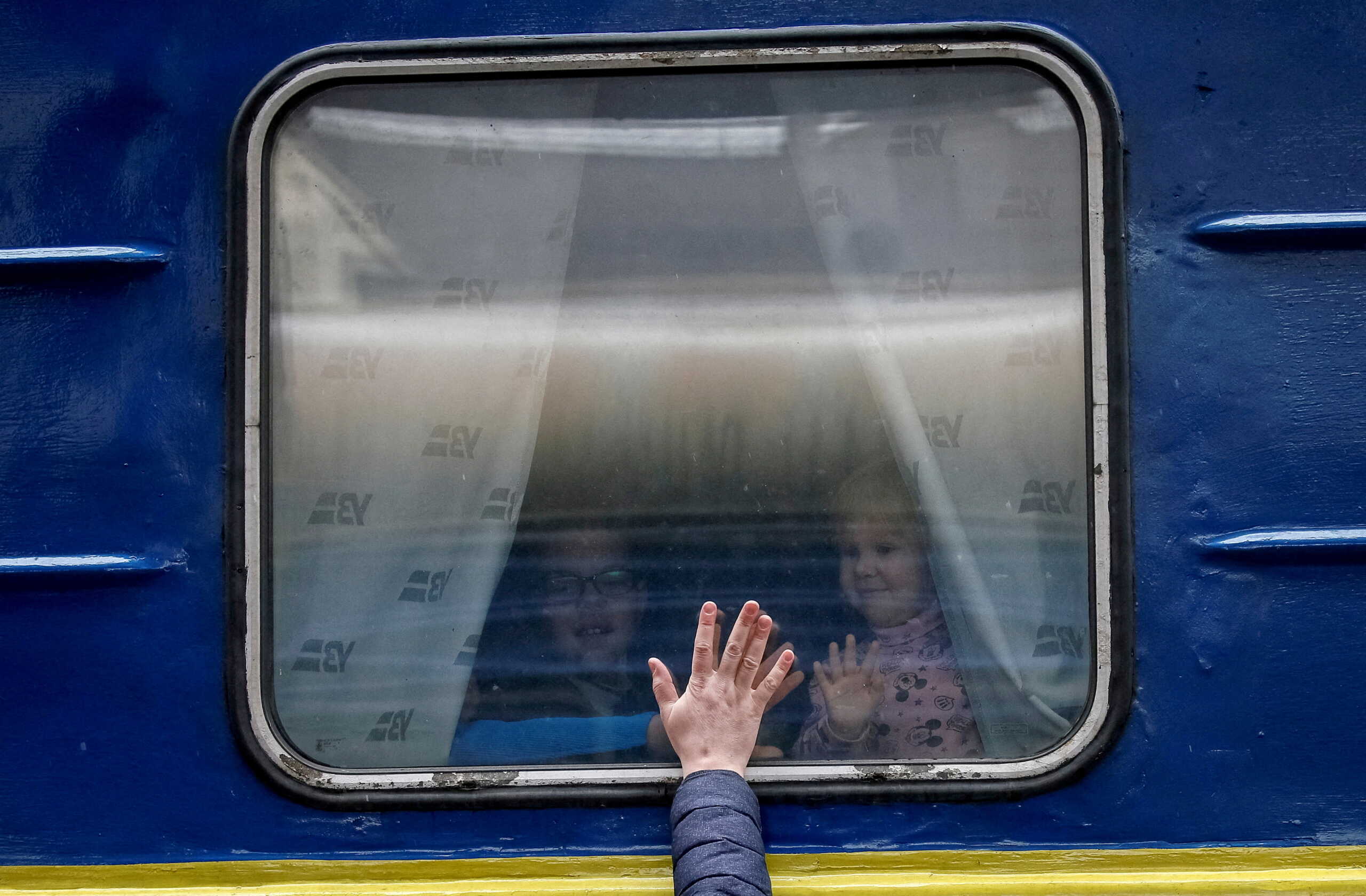FILE PHOTO: Children look out from an evacuation train from Kyiv to Lviv as they say goodbye to their father at Kyiv central train station in central Kyiv, Ukraine March 3, 2022. REUTERS