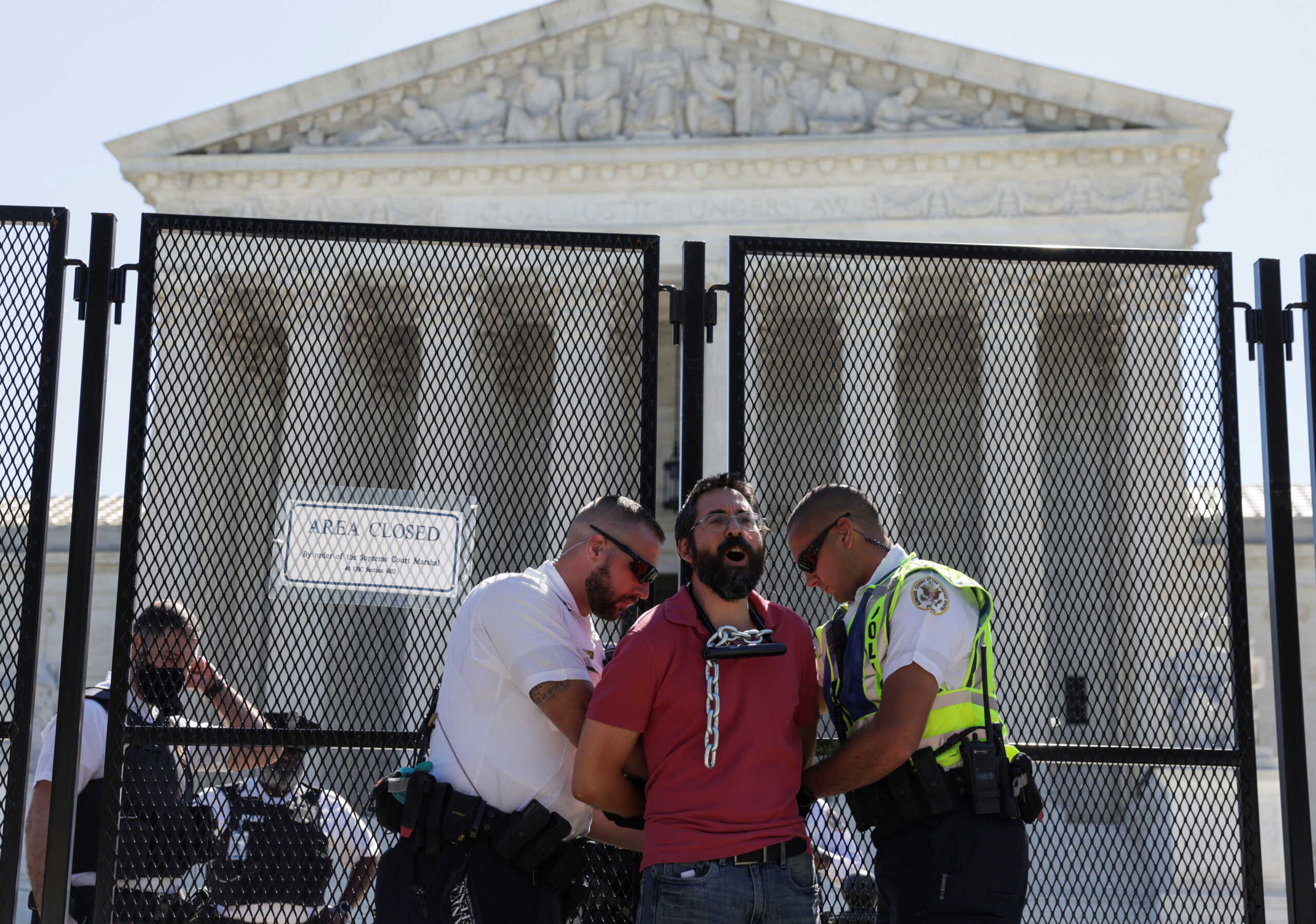 Police arrest abortion rights activist Guido Reichstadter of Miami after he chained himself to security fencing while protesting against the court's expected decision overturning the 1973 landmark Roe v Wade ruling that legalized the procedure nationwide, outside the U.S. Supreme Court in Washington, U.S., June 6, 2022. REUTERS