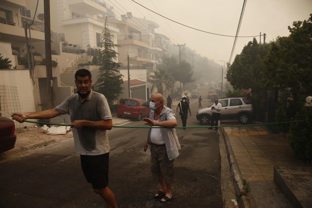 Κάτοικοι με λάστιχο επιχειρούν  στην κατάσβεση φωτιάς που καίει μέσα σε κατοικημένη περιοχή στην Άνω Βούλα, Σάββατο 4 Ιουνίου 2022. Προς τη Βούλα έχει κινηθεί η φωτιά, που ξέσπασε νωρίτερα σε περιοχή της Άνω Γλυφάδας. Κι εκεί πλέον αρχίζει να απειλείται κατοικημένη περιοχή. Μάλιστα ο δήμαρχος Βάρης-Βούλας-Βουλιαγμένης Γρηγόρης Κωνσταντέλλος ζήτησε να γίνει εκκένωση της περιοχής Πανόραμα, από την οδό Υμηττού και προς τον ορεινό όγκο και οι κάτοικοι να συνεργαστούν με τις Αρχές. ΑΠΕ-ΜΠΕ