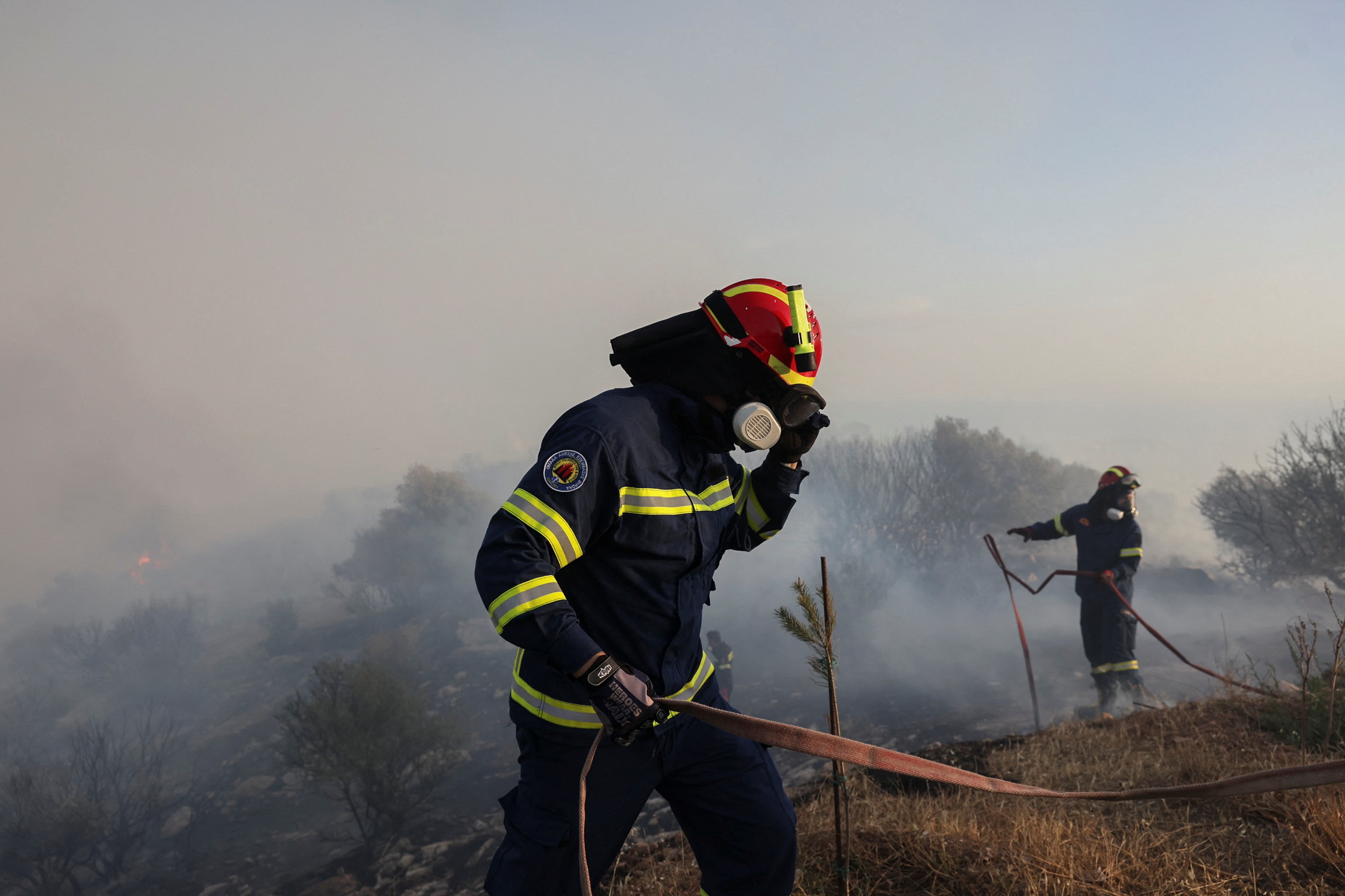 Firefighters operate as a wildfire rages in the suburb of Ano Voula in Athens, Greece, June 4, 2022. REUTERS