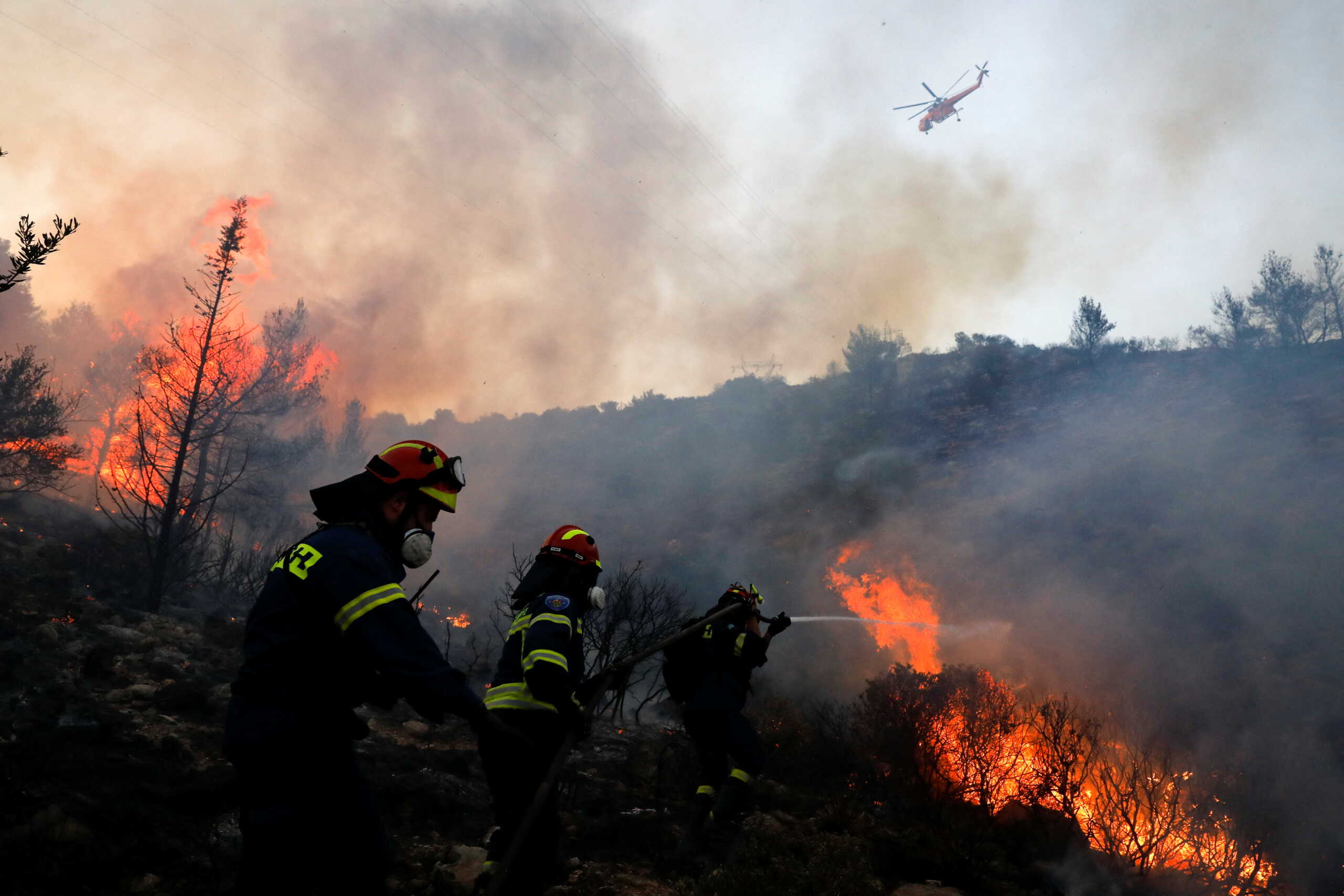 Firefighters and volunteers try to extinguish a wildfire near Vari, south of Athens, Greece June 4, 2022. REUTERS