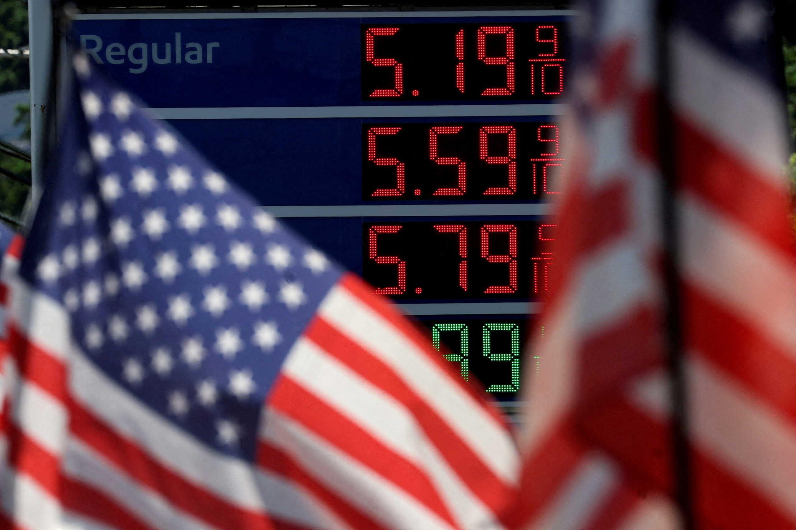 FILE PHOTO: Gasoline prices are displayed at an Exxon gas station behind American flag in Edgewater, New Jersey, U.S., June 14, 2022. REUTERS