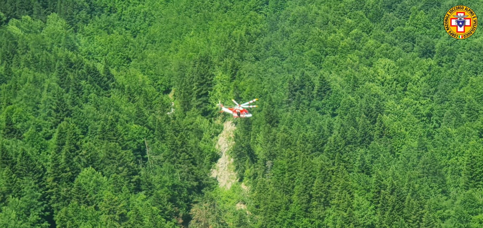 An Alpine Rescue helicopter flies over helicopter crash site near Pievepelago, Italy, June 11, 2022. Corpo Nazionale Soccorso Alpino e Speleologico