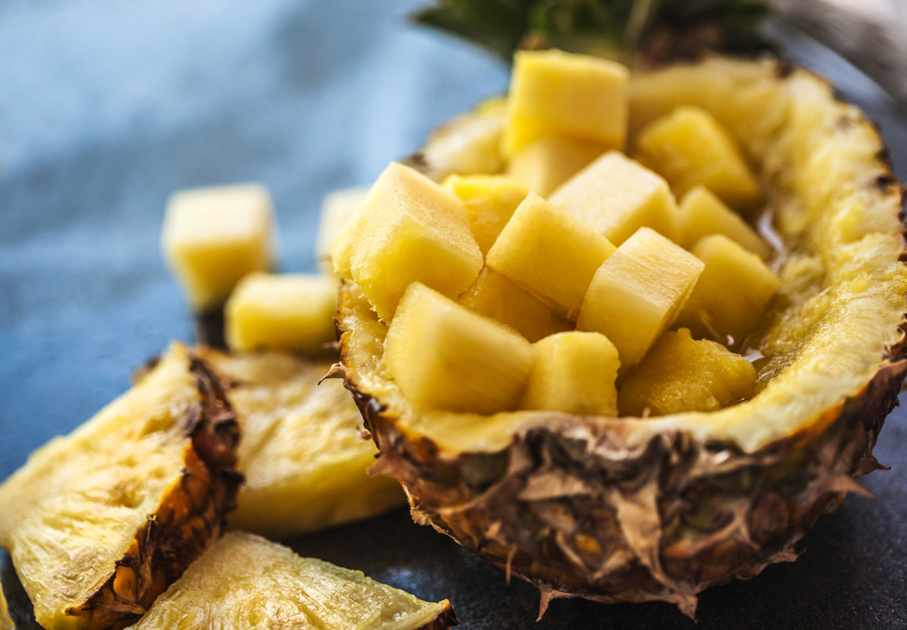 Pineapple smoothie with fresh pineapple on wooden table