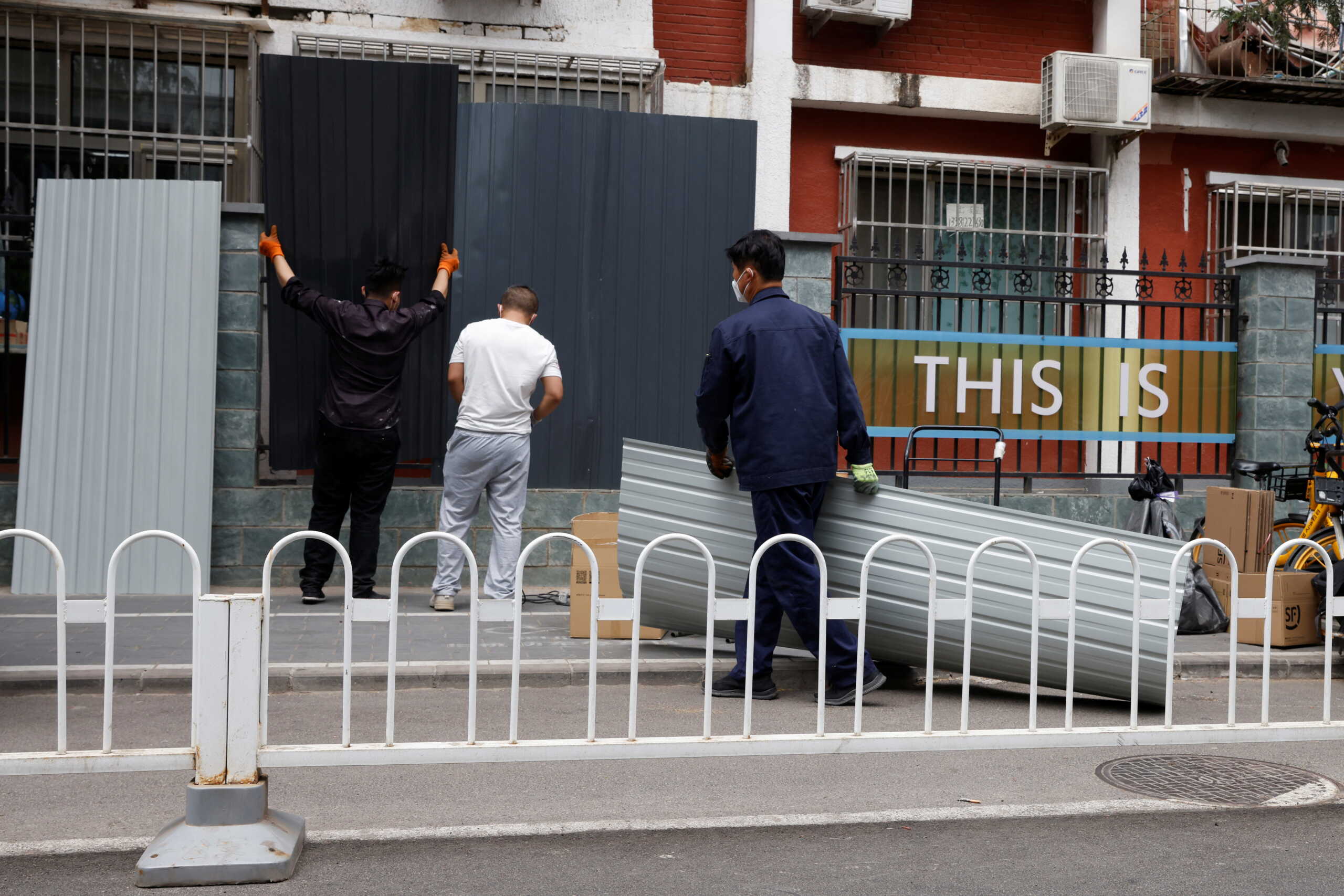 Workers install a barricade around a residential area under lockdown, amid the coronavirus disease (COVID-19) outbreak in Beijing, China June 10, 2022. REUTERS