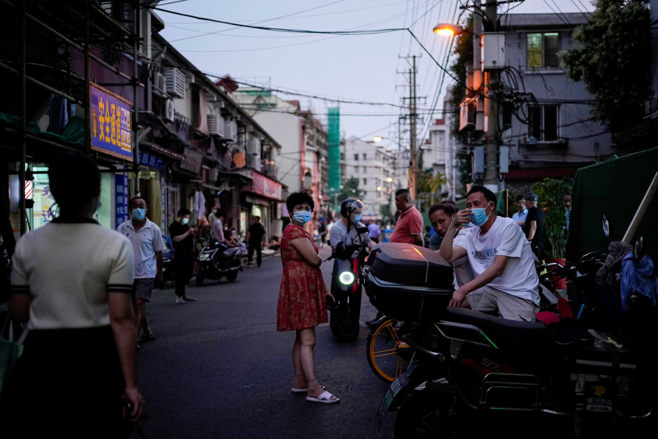 People chat on a street at a residential area, amid new lockdown measures in parts of the city to curb the coronavirus disease (COVID-19) outbreak in Shanghai, China, June 15, 2022. REUTERS