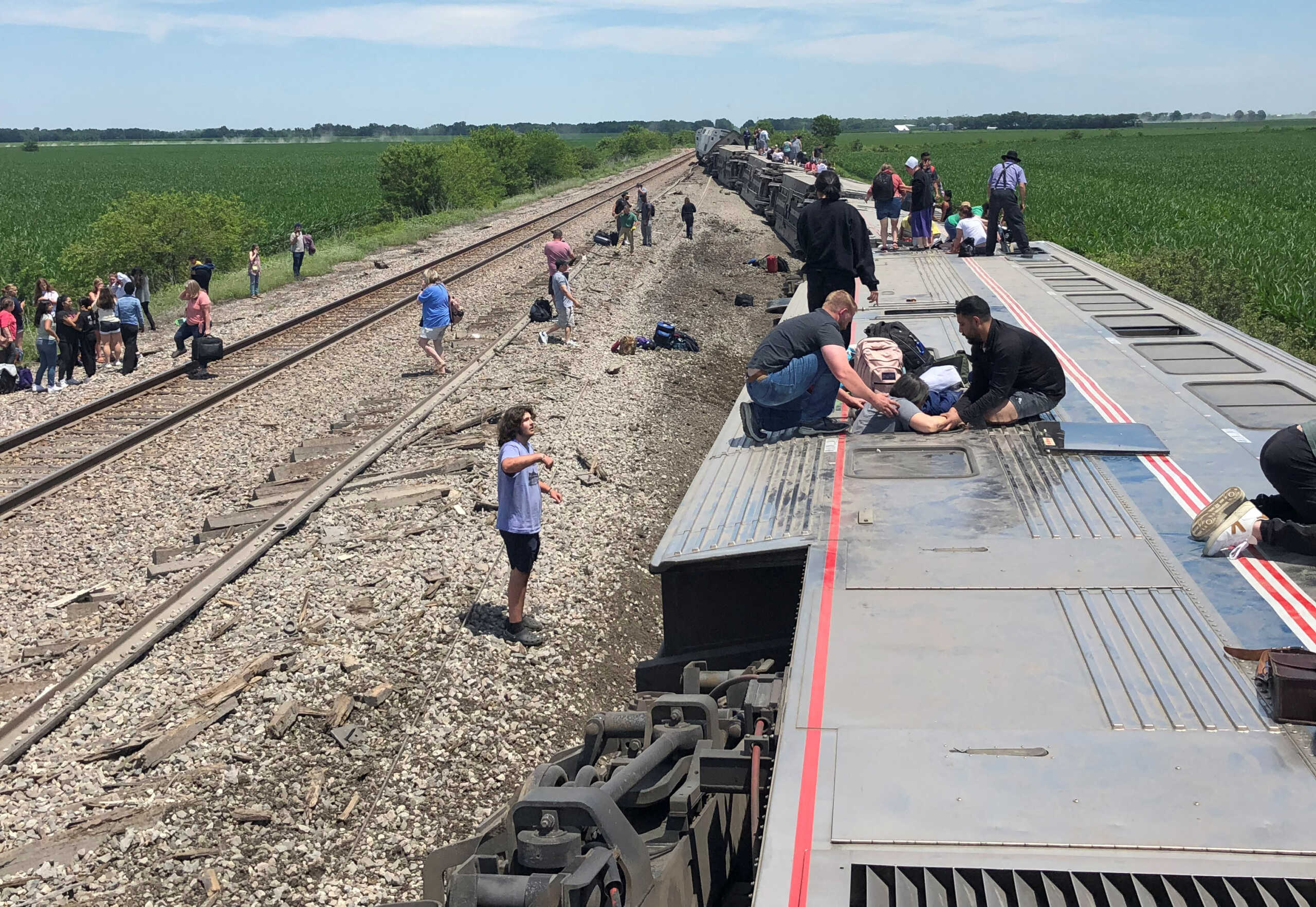 People exit from an Amtrak train that derailed after hitting a dump truck at an uncontrolled crossing, near Mendon, Missouri, U.S., June 27, 2022 in this picture obtained from social media. Dax McDonald