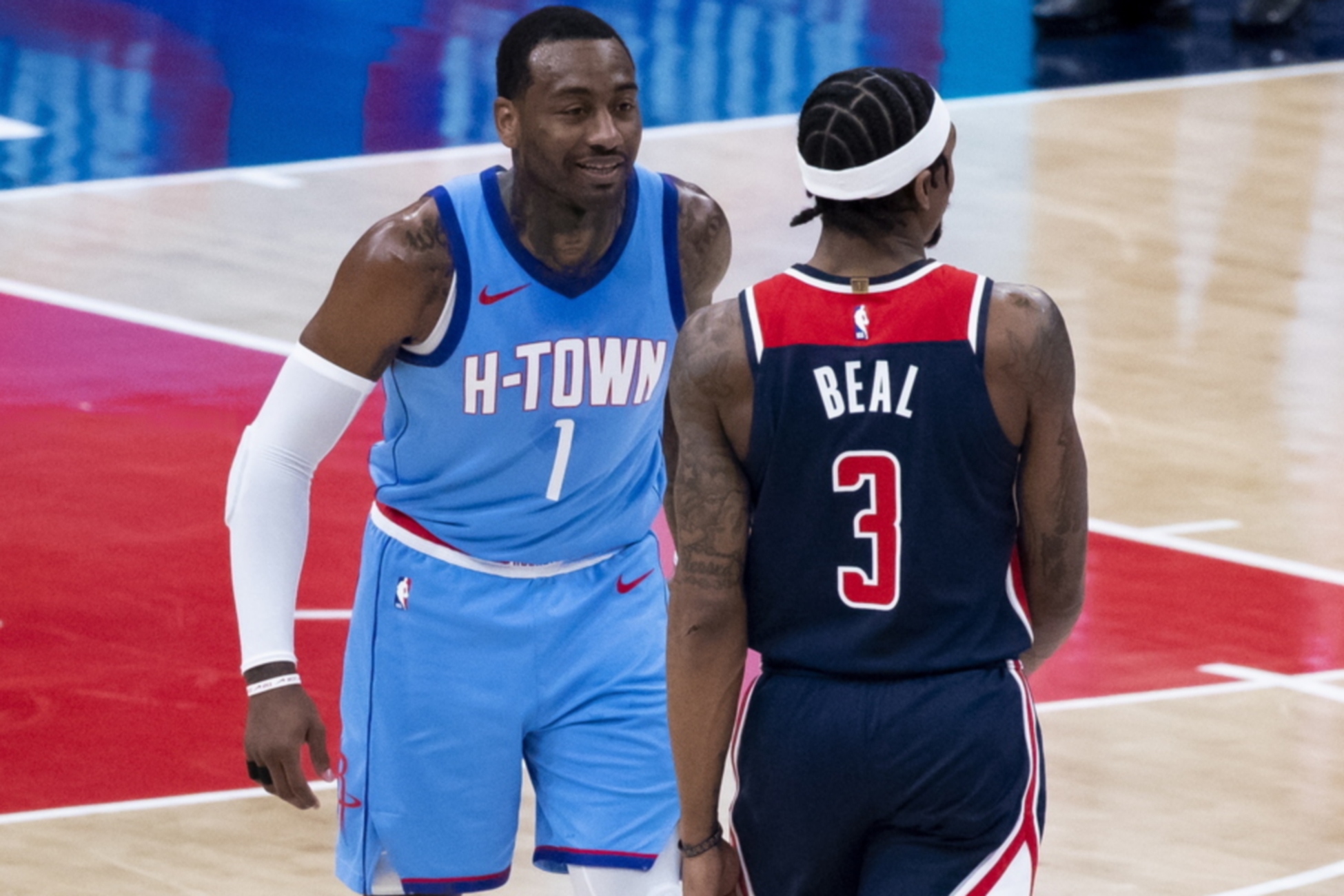epa09015222 Houston Rockets guard John Wall (C) speaks with Washington Wizards guard Bradley Beal (R) during the NBA basketball game between the Houston Rockets and the Washington Wizards at Capital One Arena in Washington, DC, USA, 15 February 2021.  EPA