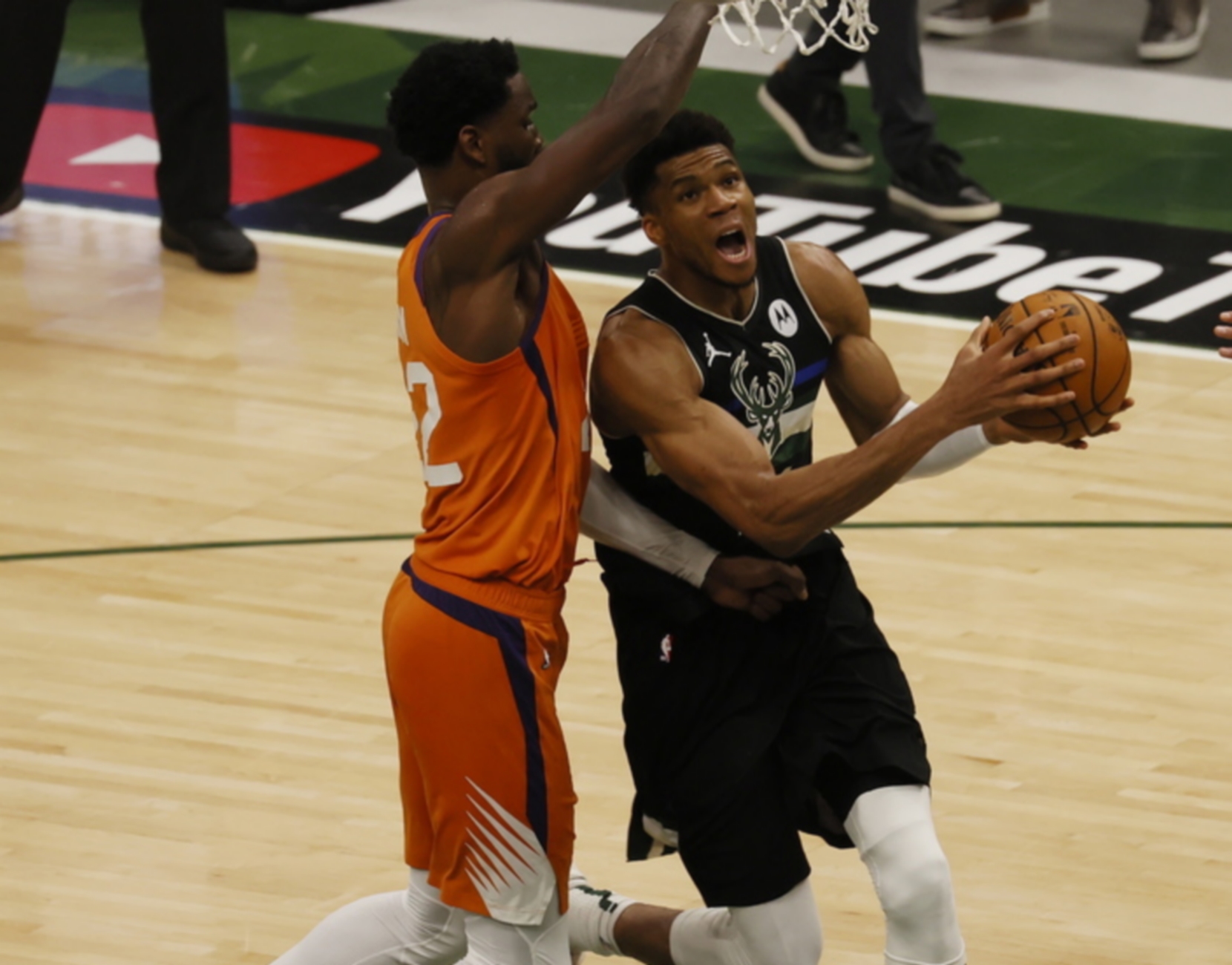 epa09355785 Milwaukee Bucks foreward Giannis Antetokounmpo (R) drives past Phoenix Suns center Deandre Ayton (L) in the third quarter of game six of the NBA Finals basketball series between the Phoenix Suns and the Milwaukee Bucks at Fiserv Forum in Milwaukee, Wisconsin, USA, 20 July 2021. The Bucks lead the best-of-seven series 3-2 and can clinch the NBA Finals with a win.  EPA