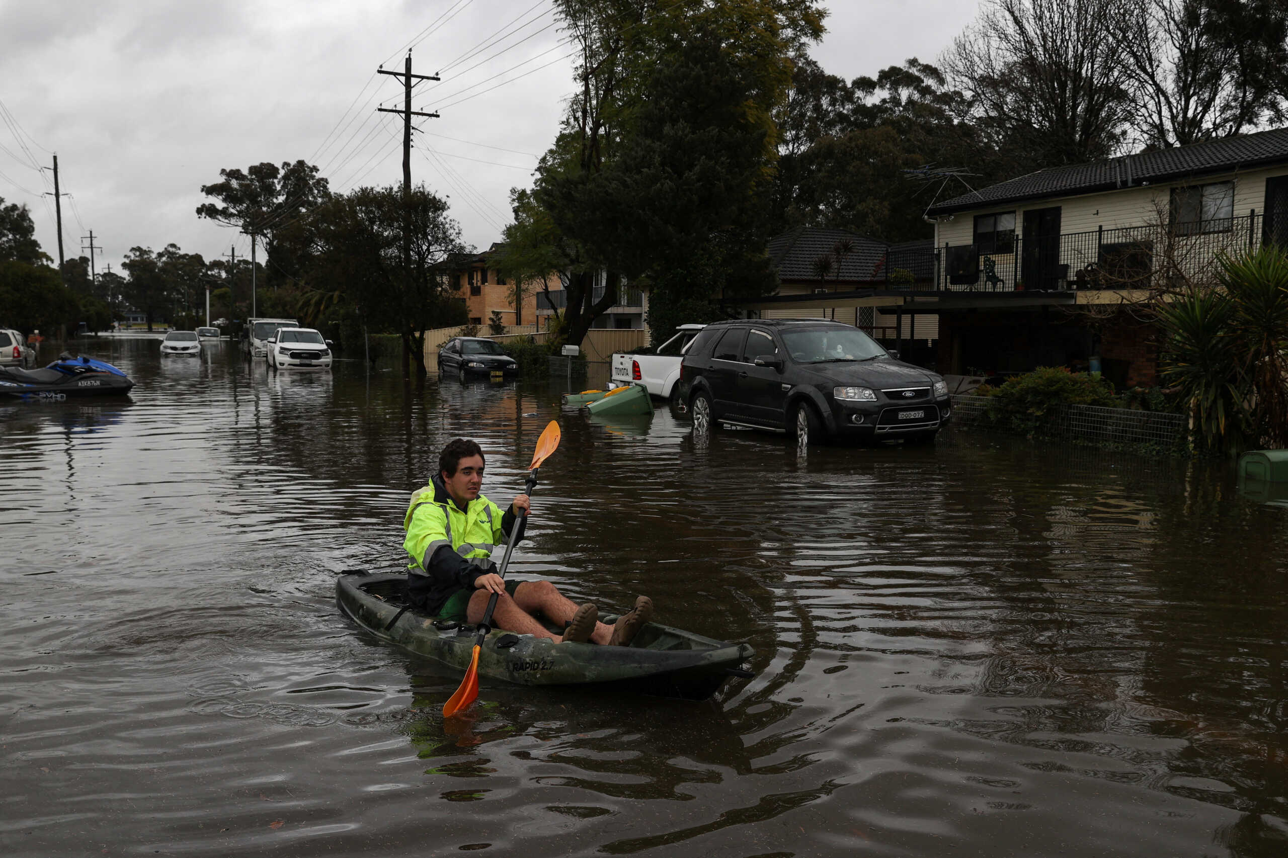 A kayaker paddles through a flooded residential area following heavy rains in the South Windsor suburb of Sydney, Australia, July 5, 2022.  REUTERS