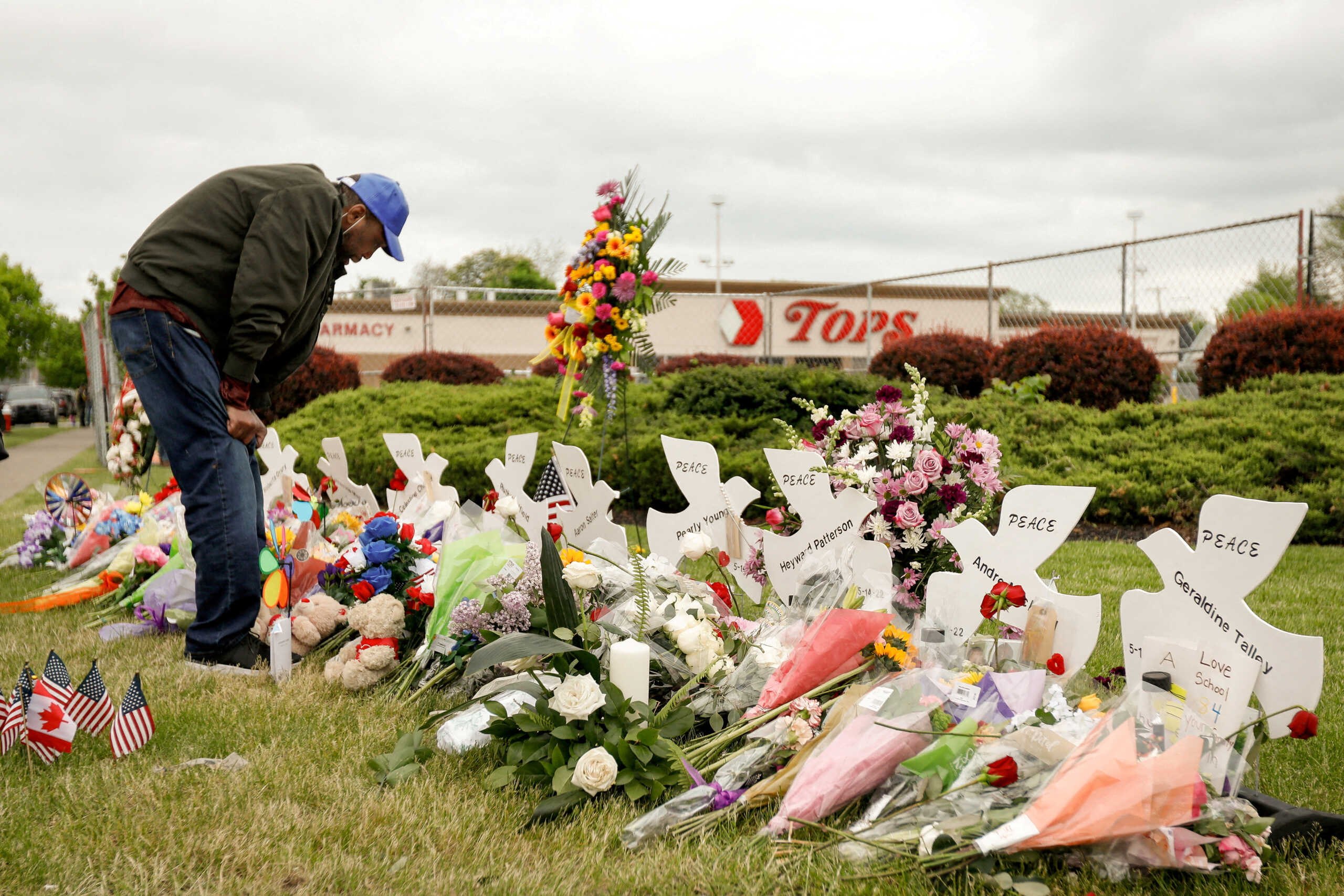 FILE PHOTO: A man mourns at a memorial at the scene of a weekend shooting at a Tops supermarket in Buffalo, New York, U.S. May 20, 2022.  REUTERS