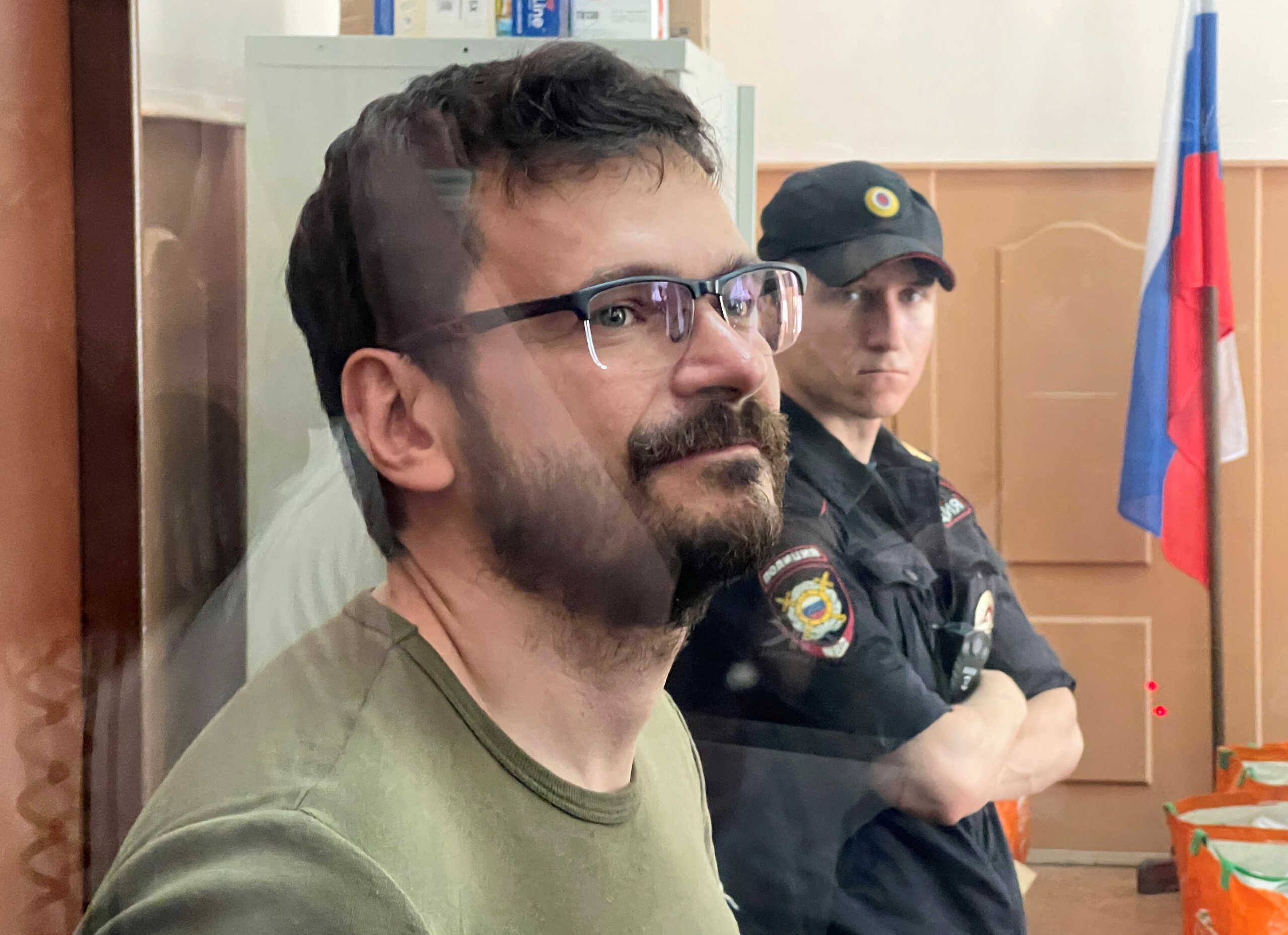 Russian opposition politician Ilya Yashin, detained on suspicion of spreading false information about Russia's army, stands inside a defendants' cage during a court hearing in Moscow, Russia July 13, 2022. REUTERS