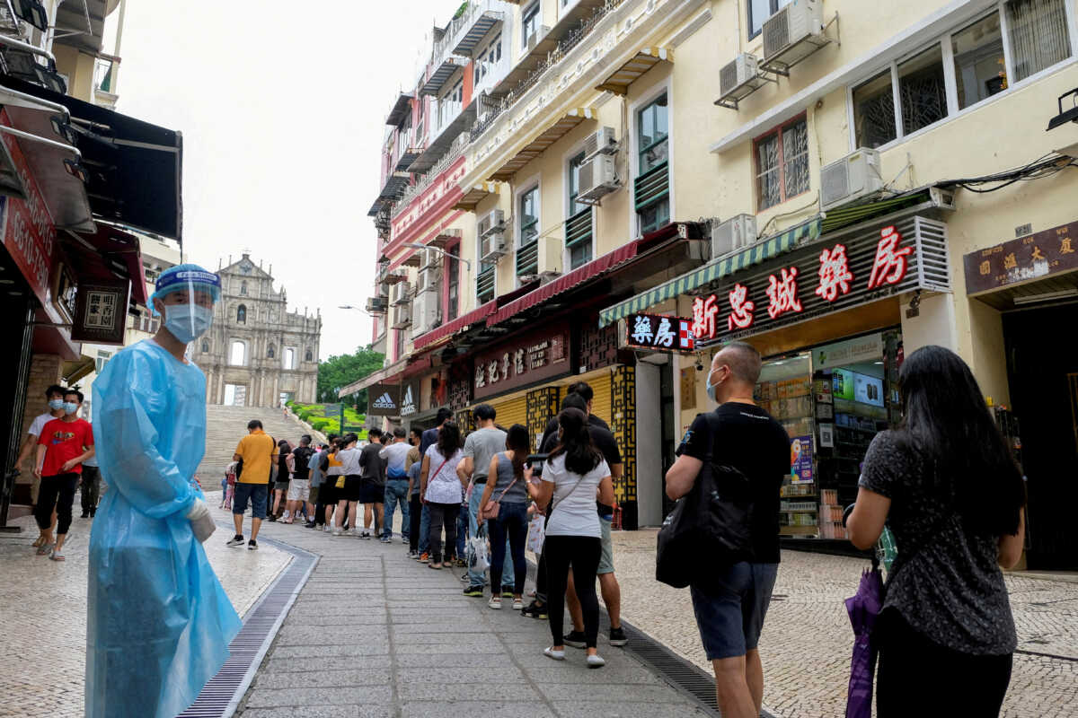 FILE PHOTO: People queue for COVID-19 testing in Macau, China, June 20, 2022. REUTERS