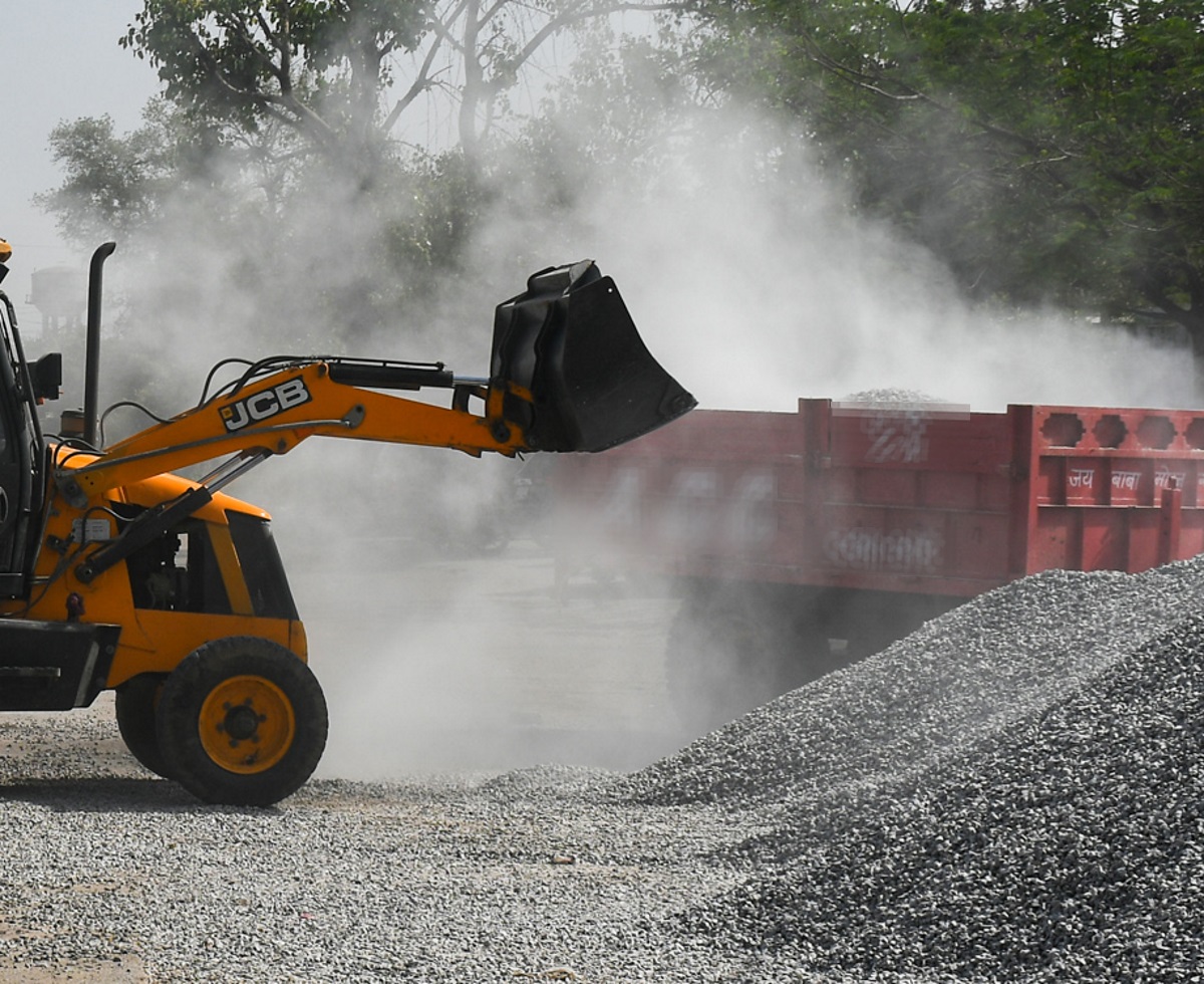 A driver picks up gravel from a roadside in Bhiwadi, India on March 29, 2022. Thomson Reuters Foundation