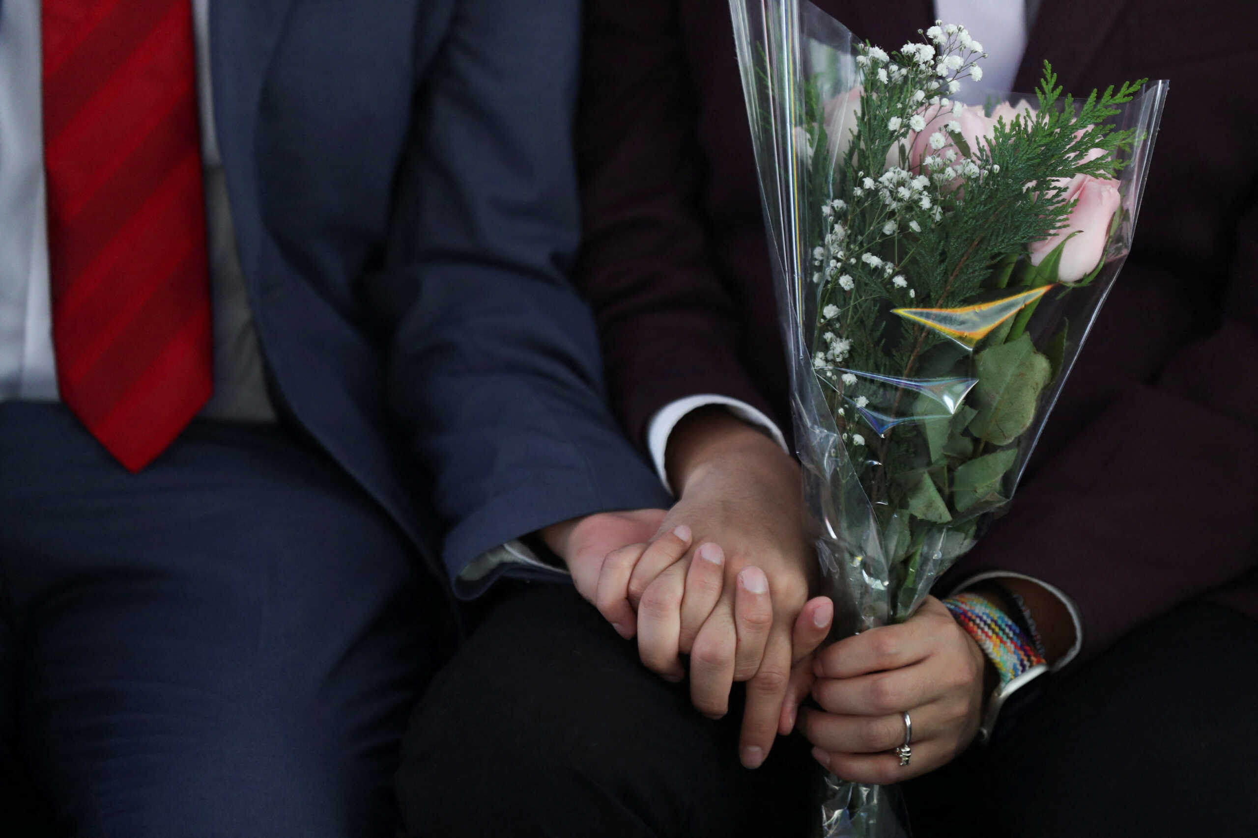 A couple holds hands as they celebrate LGBTQ+ pride month with a massive wedding of same sex couples in Mexico City, Mexico, June 24, 2022. REUTERS