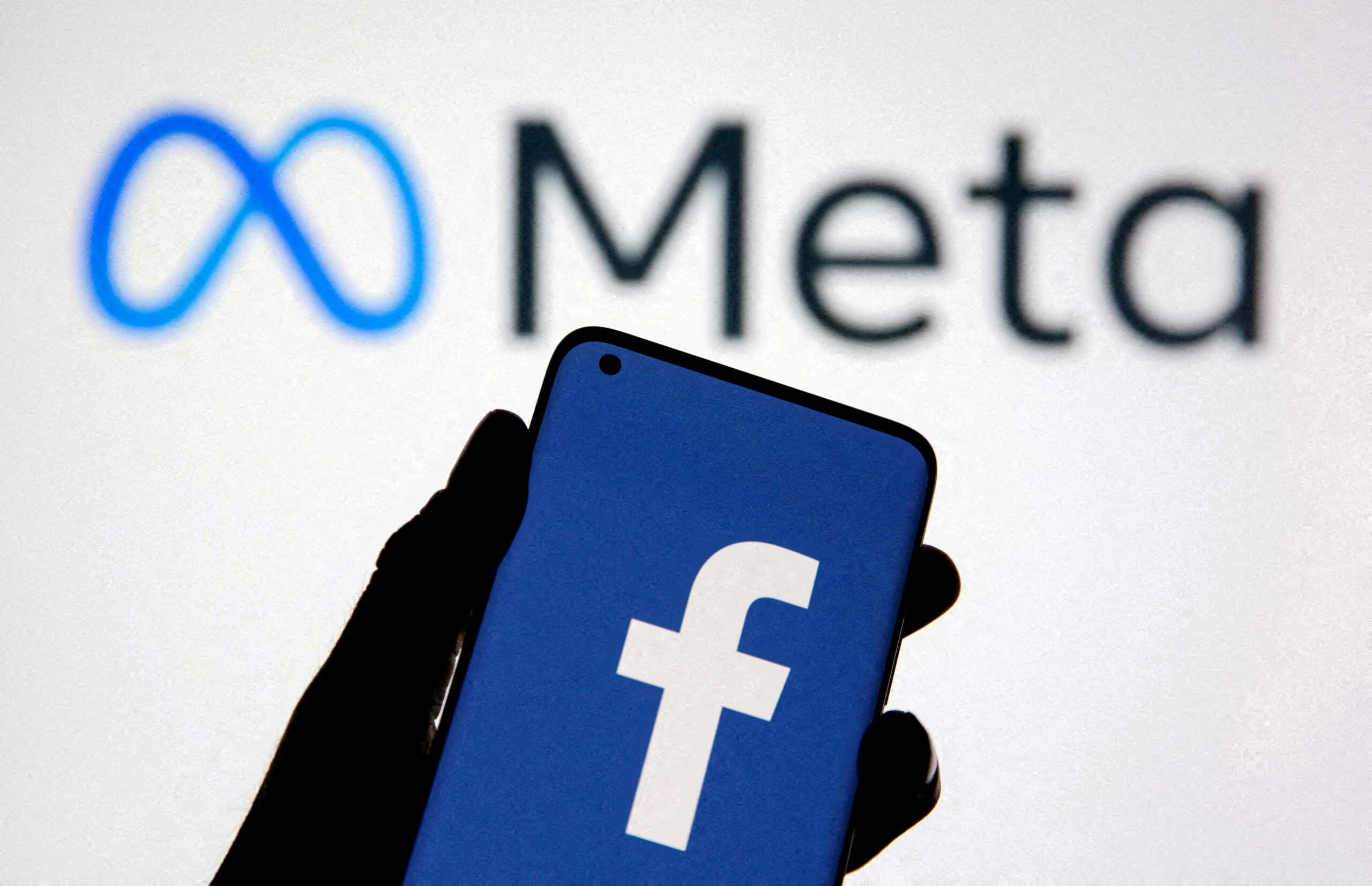 FILE PHOTO: A smartphone with Facebook's logo is seen with new rebrand logo Meta in this illustration taken October 28, 2021. REUTERS