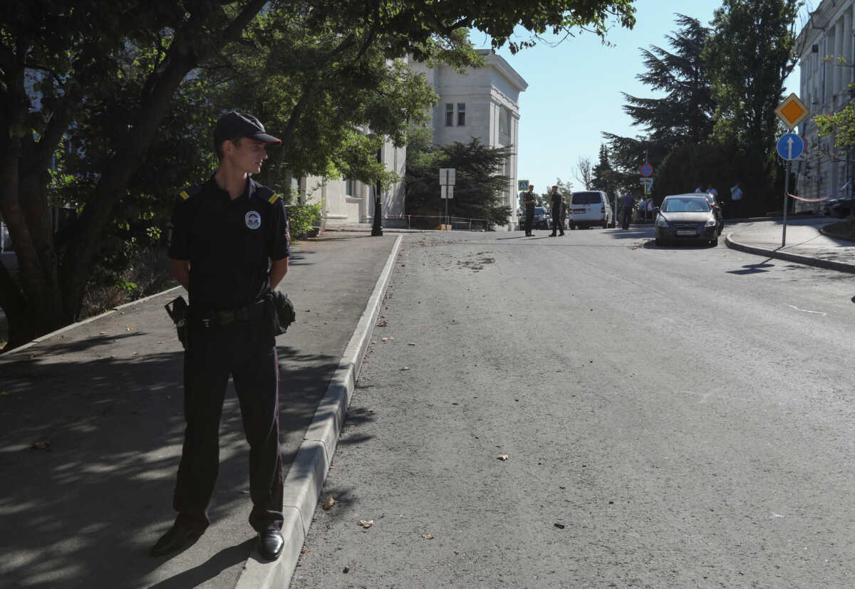 A Russian law enforcement officer stands guard near the Russian Black Sea Fleet's headquarters following a reported combat drone attack in Sevastopol, Crimea July 31, 2022. REUTERS