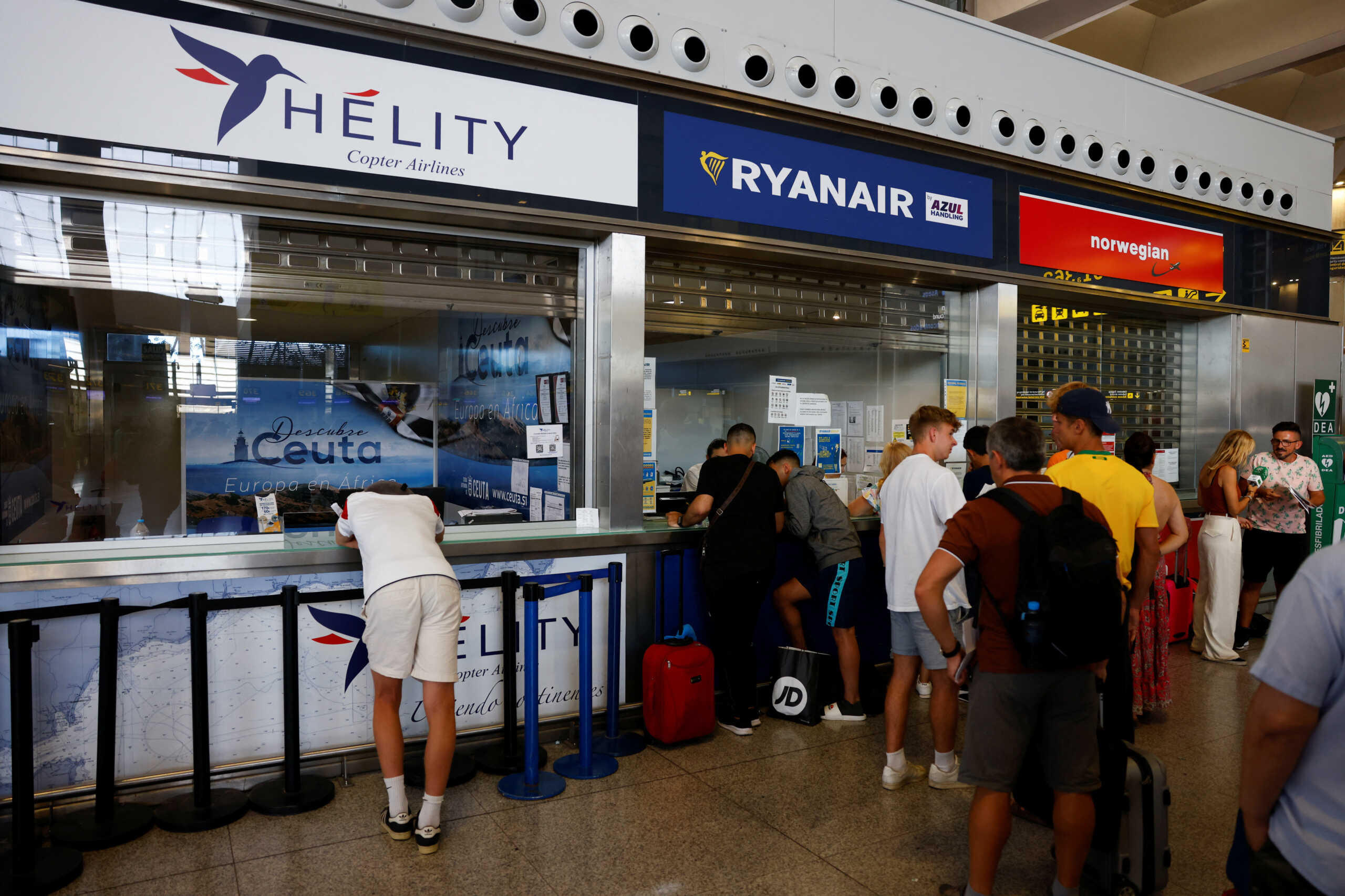 The stranded Ryanair passengers wait to receive information at the Ryanair information desk at Malaga-Costa del Sol Airport during the cabin crew strike, in Malaga, Spain, June 30, 2022. REUTERS