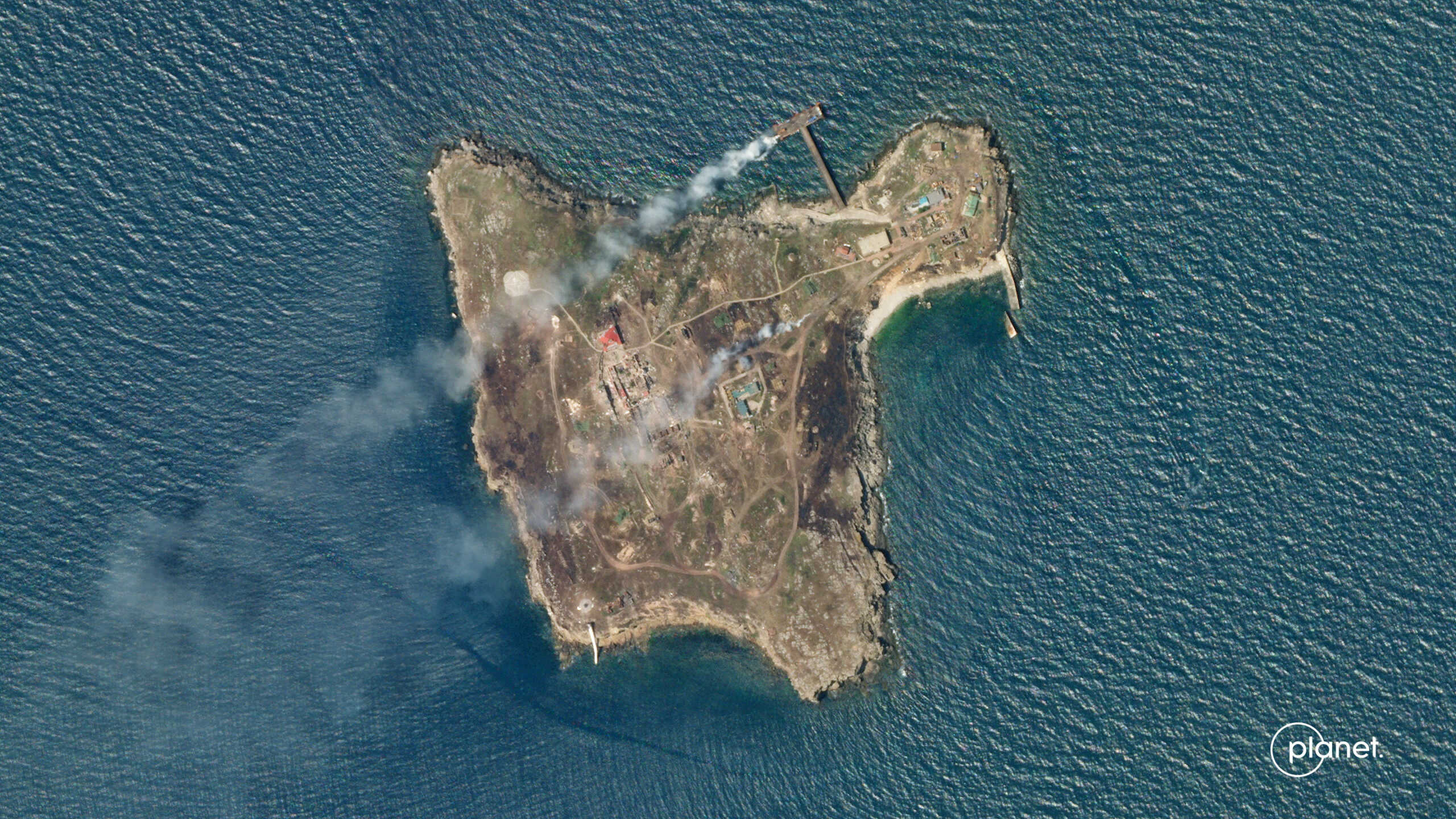 A satellite image shows smoke rising from Snake Island, off the coast of Ukraine, June 29, 2022.    Planet Labs PBC
