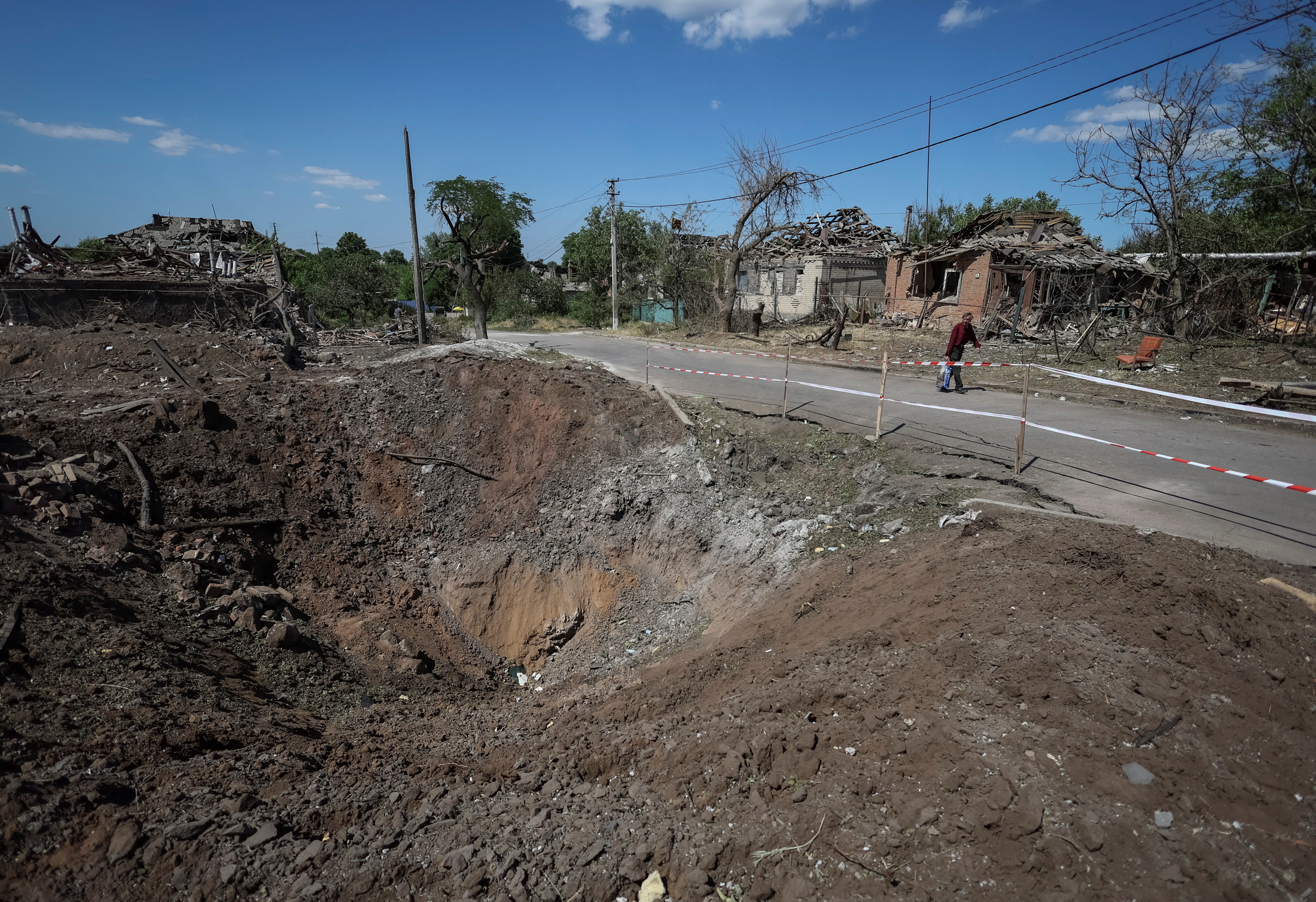A shell crater is seen near buildings destroyed by Russian military strike, amid Russia's invasion on Ukraine, in the town of Druzhkivka, in Donetsk region, Ukraine June 6, 2022. REUTERS