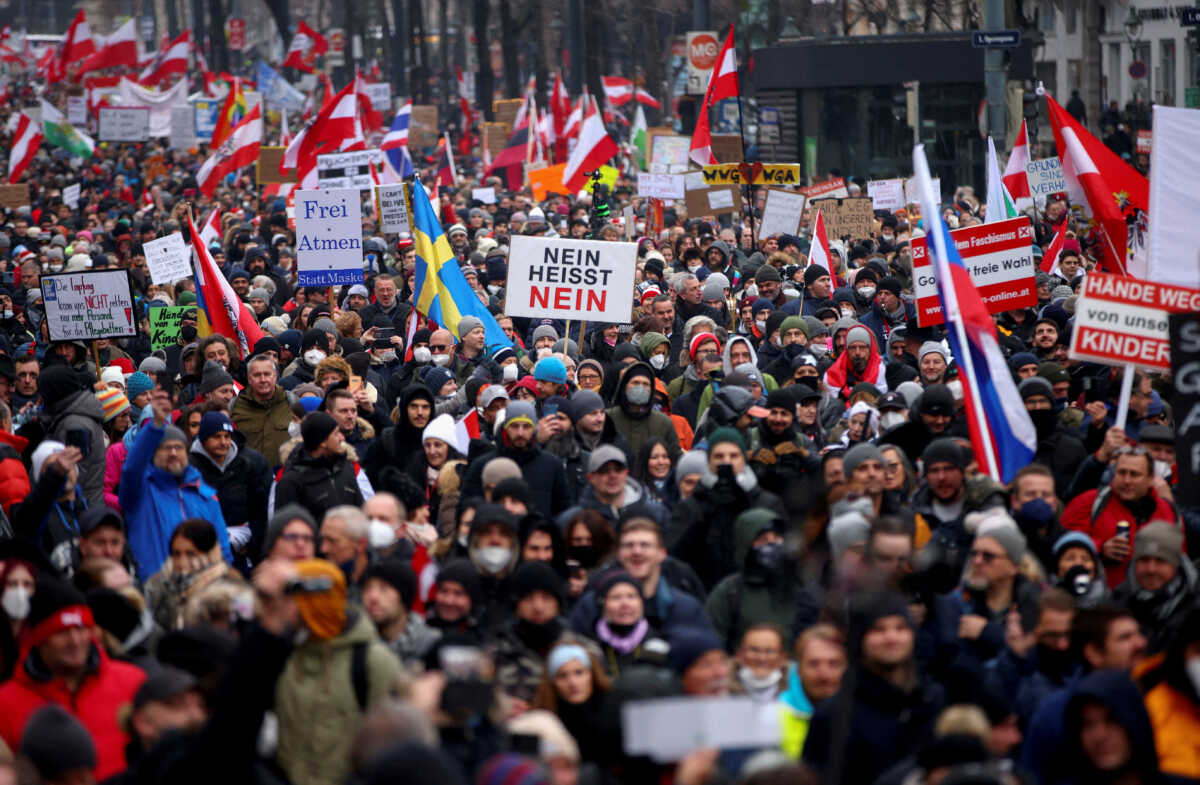 FILE PHOTO: Demonstrators hold flags and placards as they march to protest against the coronavirus disease (COVID-19) restrictions and the vaccine mandate in Vienna, Austria, December 11, 2021. REUTERS