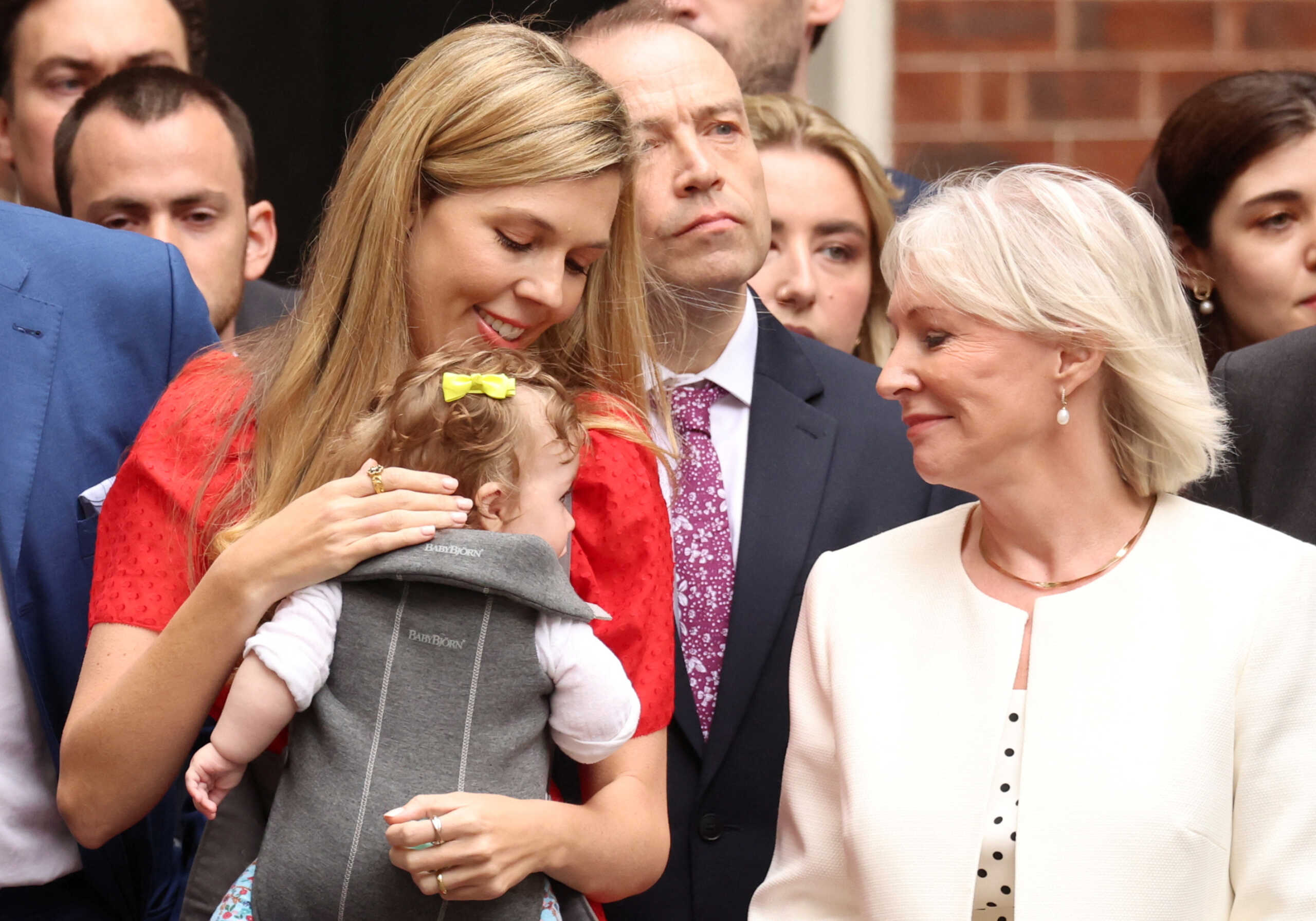 Carrie Johnson with her baby and British Culture Secretary Nadine Dorries stand as British Prime Minister Boris Johnson (not pictured) makes a statement at Downing Street in London, Britain, July 7, 2022. REUTERS