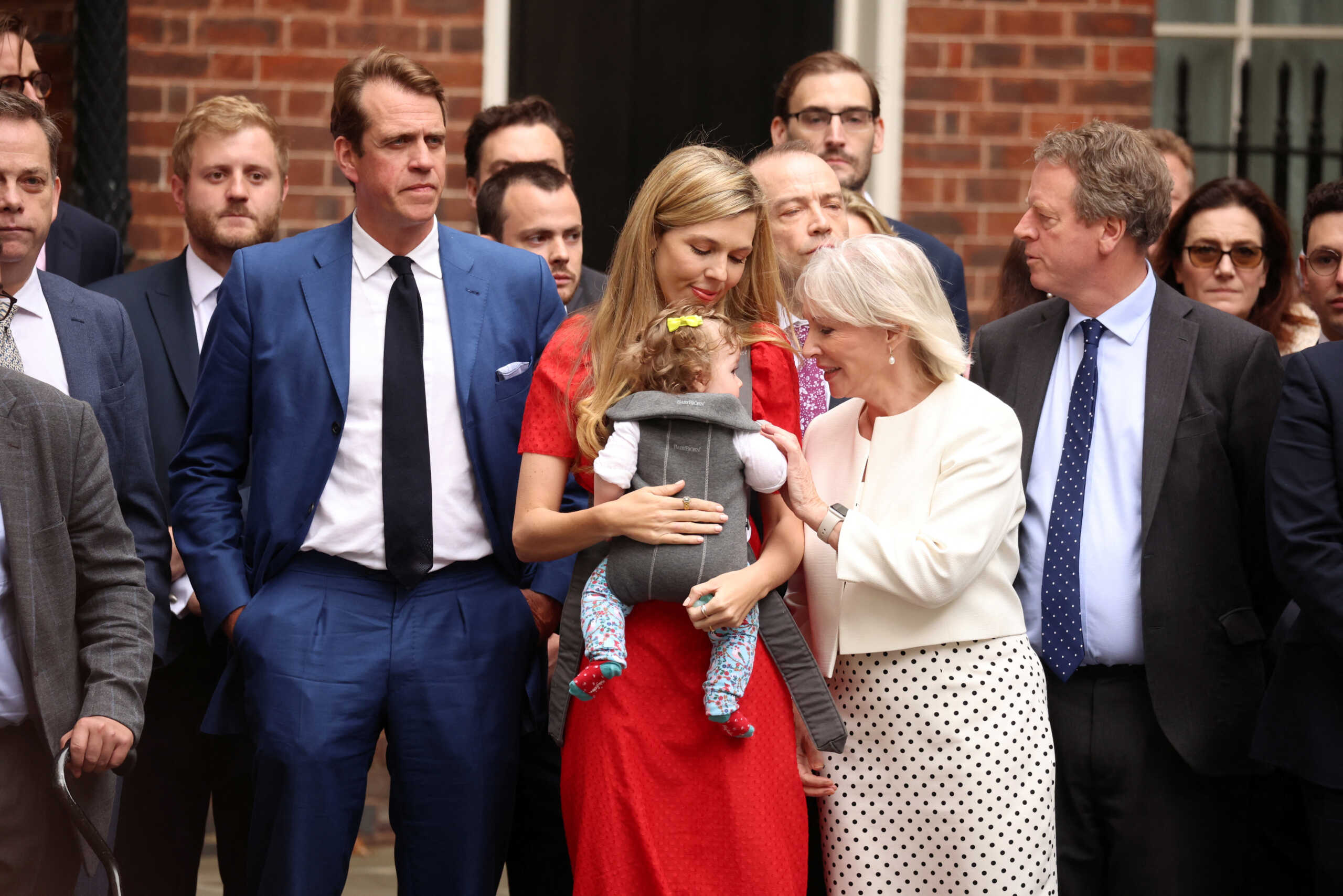 Carrie Johnson with her baby and British Culture Secretary Nadine Dorries stand as British Prime Minister Boris Johnson (not pictured) makes a statement at Downing Street in London, Britain, July 7, 2022. REUTERS