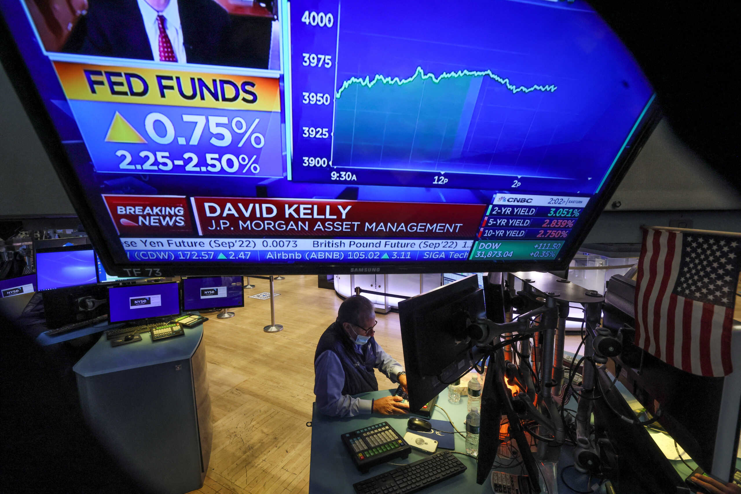 A screen displays the Fed rate announcement as a trader works on the floor of the New York Stock Exchange (NYSE) in New York City, U.S., July 27, 2022. REUTERS