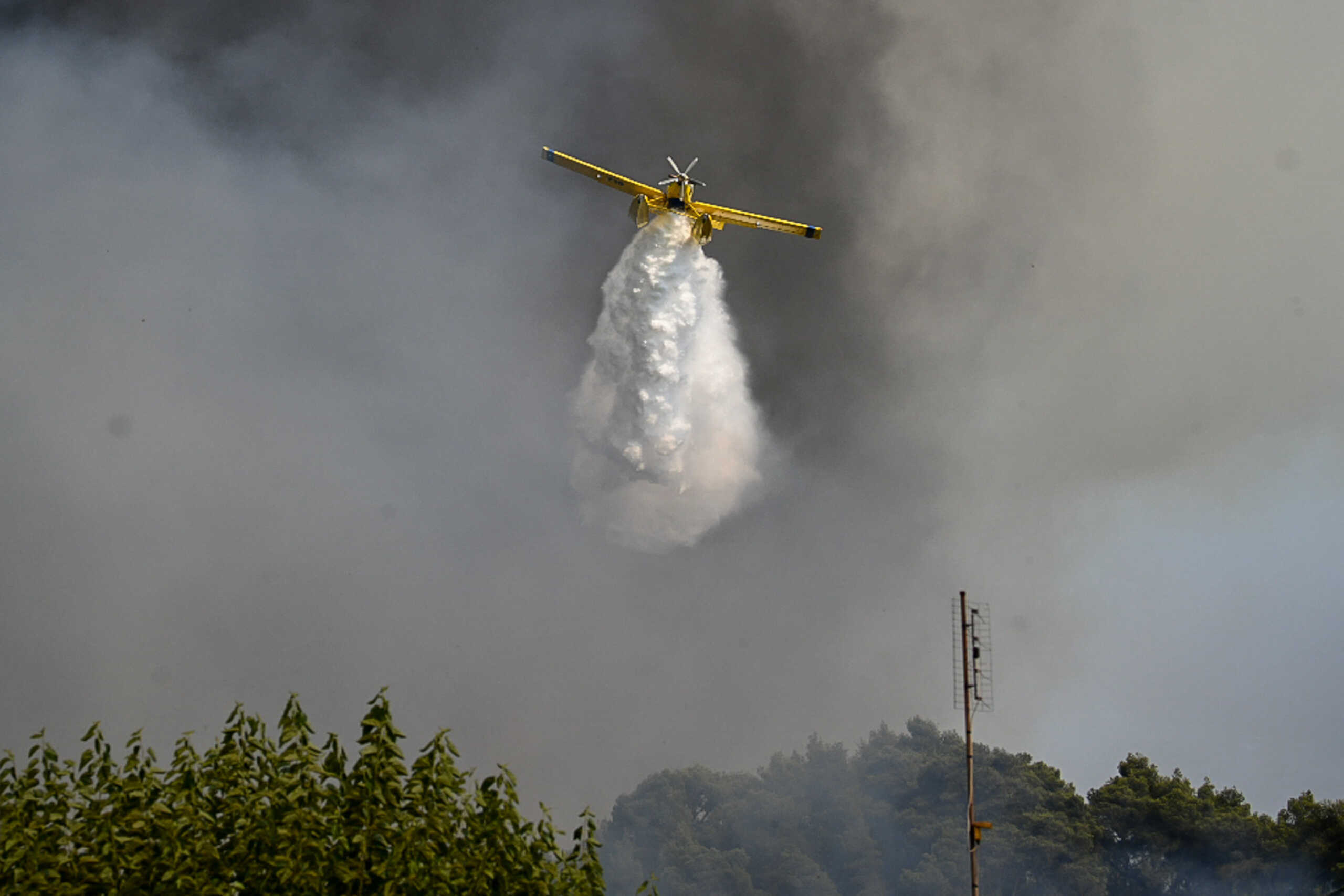 A firefighting plane makes a water drop as a wildfire burns at the village of Krestena, in the western Peloponnese, Greece July 24, 2022. Giannis Spirounis