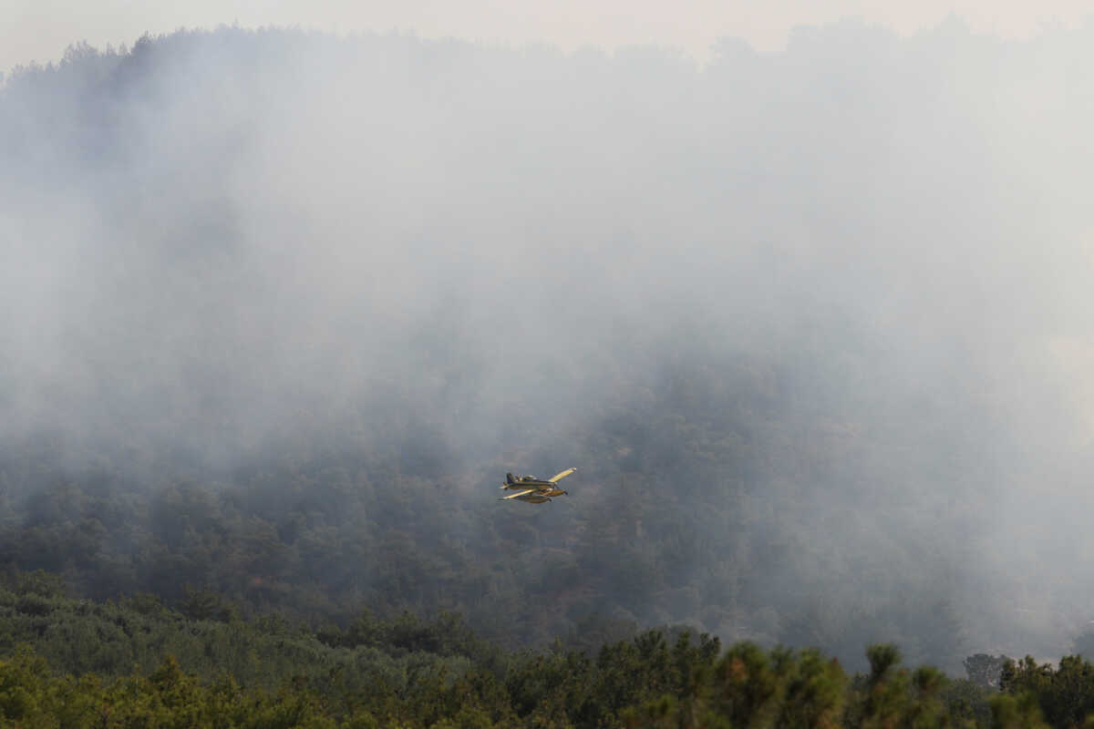 A firefighting plane flies over wildfire burning near the village of Vatera, on the island of Lesbos, Greece, July 24, 2022. REUTERS