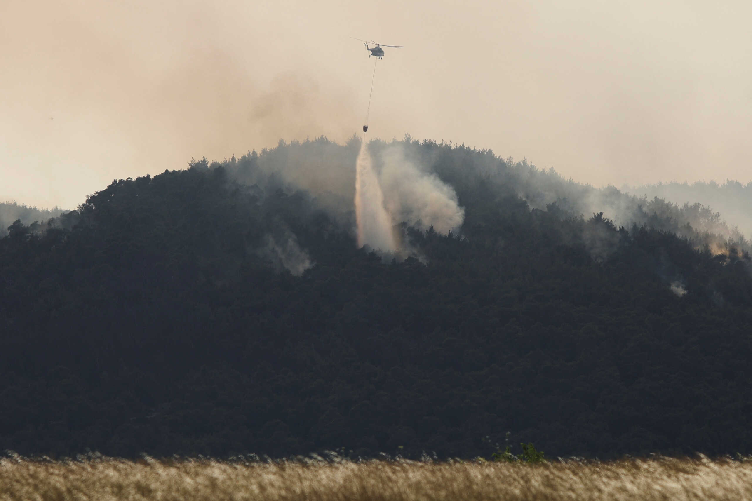 A firefighting helicopter drops water during a wildfire in the Dadia National Park, in Evros, Greece, July 25, 2022. REUTERS