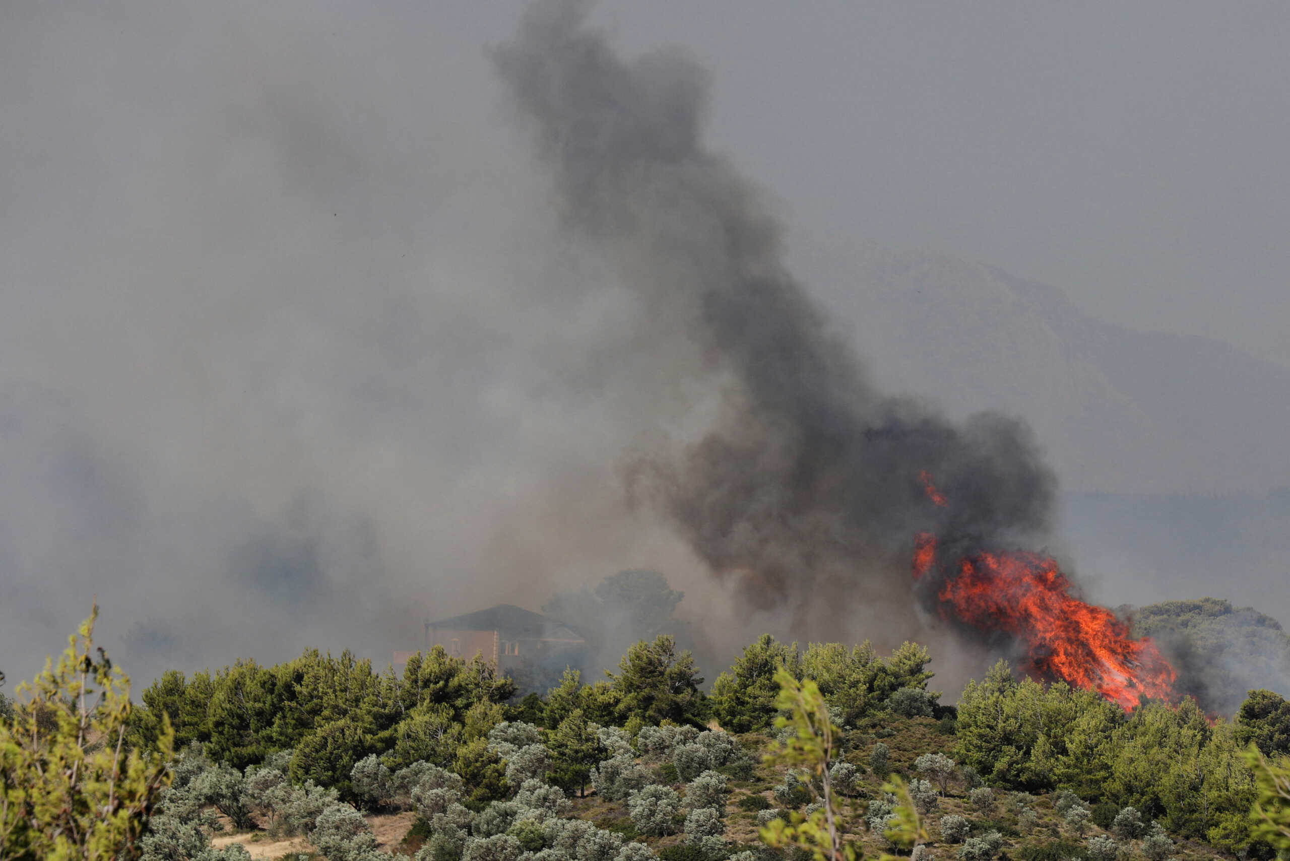 A house is engulfed in smoke as a wildfire burns nearby in the Pikermi suburb of Athens, Greece, July 20, 2022. REUTERS