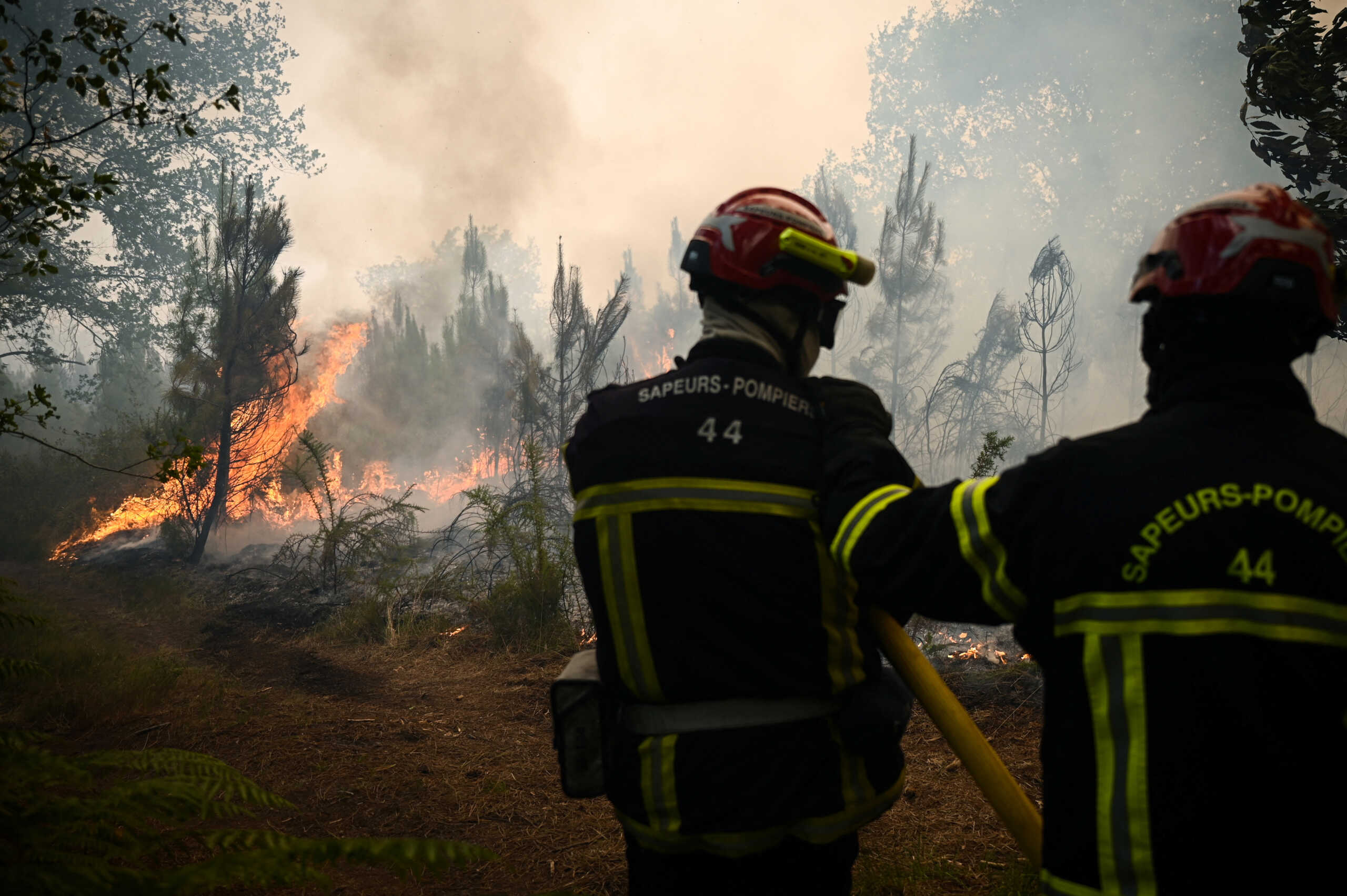 Firefighters take positions as smoke rises from a forest fire near Louchats, as wildfires continue to spread in the Gironde region of southwestern France, July 18, 2022. Philippe Lopez