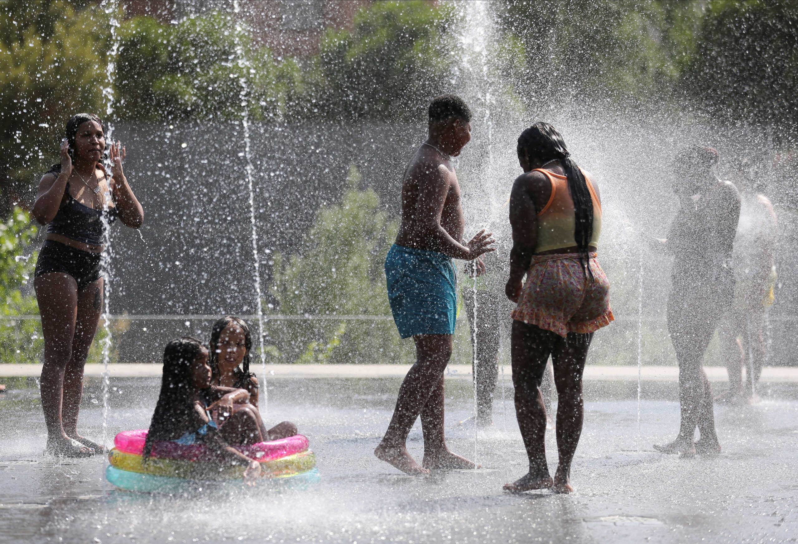 People cool off at a fountain in Madrid Rio Park during the second heatwave of the year in Madrid, Spain, July 14, 2022. REUTERS