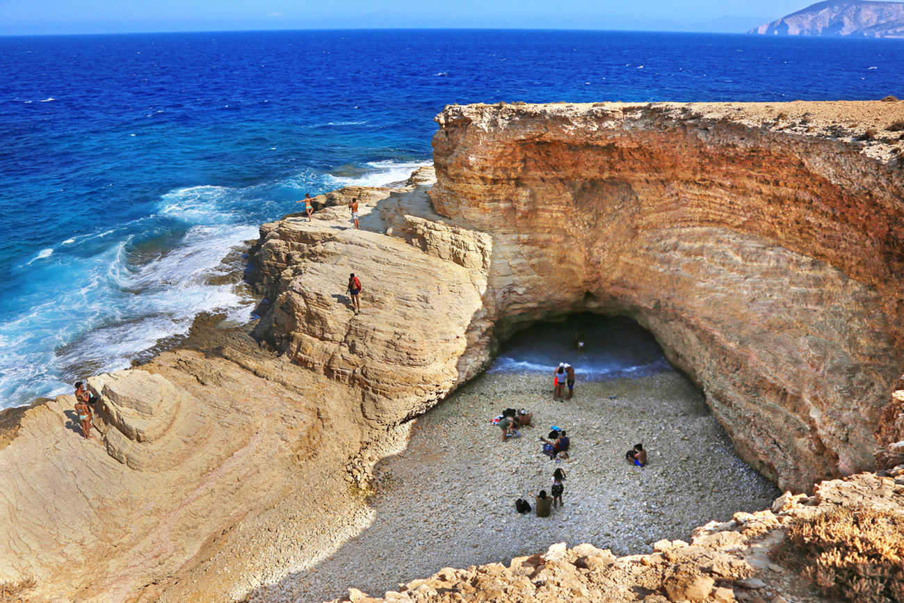 Ano Koufonisi Greece, August 27 2019: the famous Gala beach at Ano Koufonisi island Greece - the sea enters the beach via a narrow corridor of the open cave of the rocks - Gala means milk in the greek language.