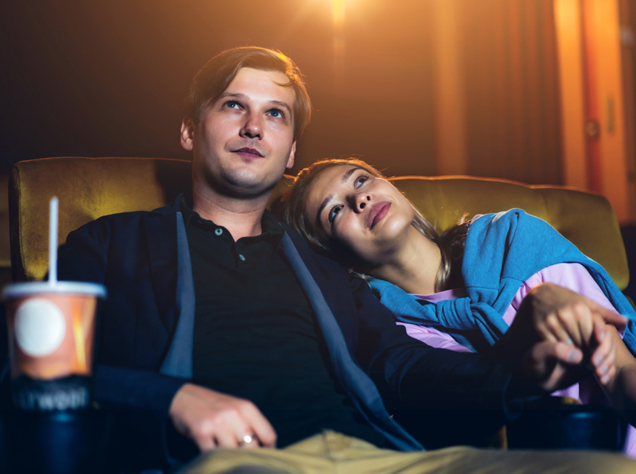 Caucasian lover enjoying to watch movie and eating popcorn together in the cinema