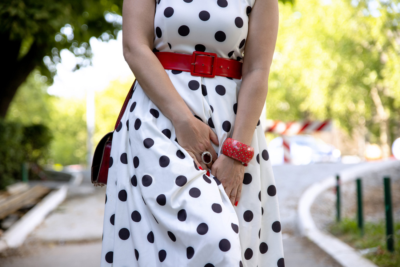 Woman having incontinence or urinary infection problem in the street outdoor. Female in dress pressing her bladder to control urination. Hands holding crotch