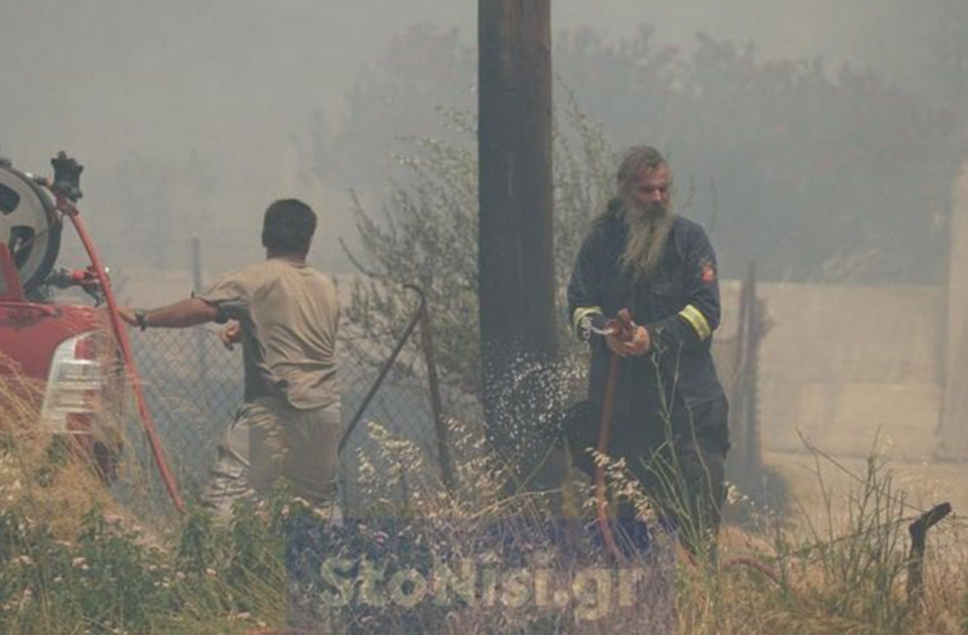 Φωτιά στη Λέσβο: Δύο ιερείς στη μάχη με τις φλόγες – Με το μπουφάν του εθελοντή πάνω από τα ράσα