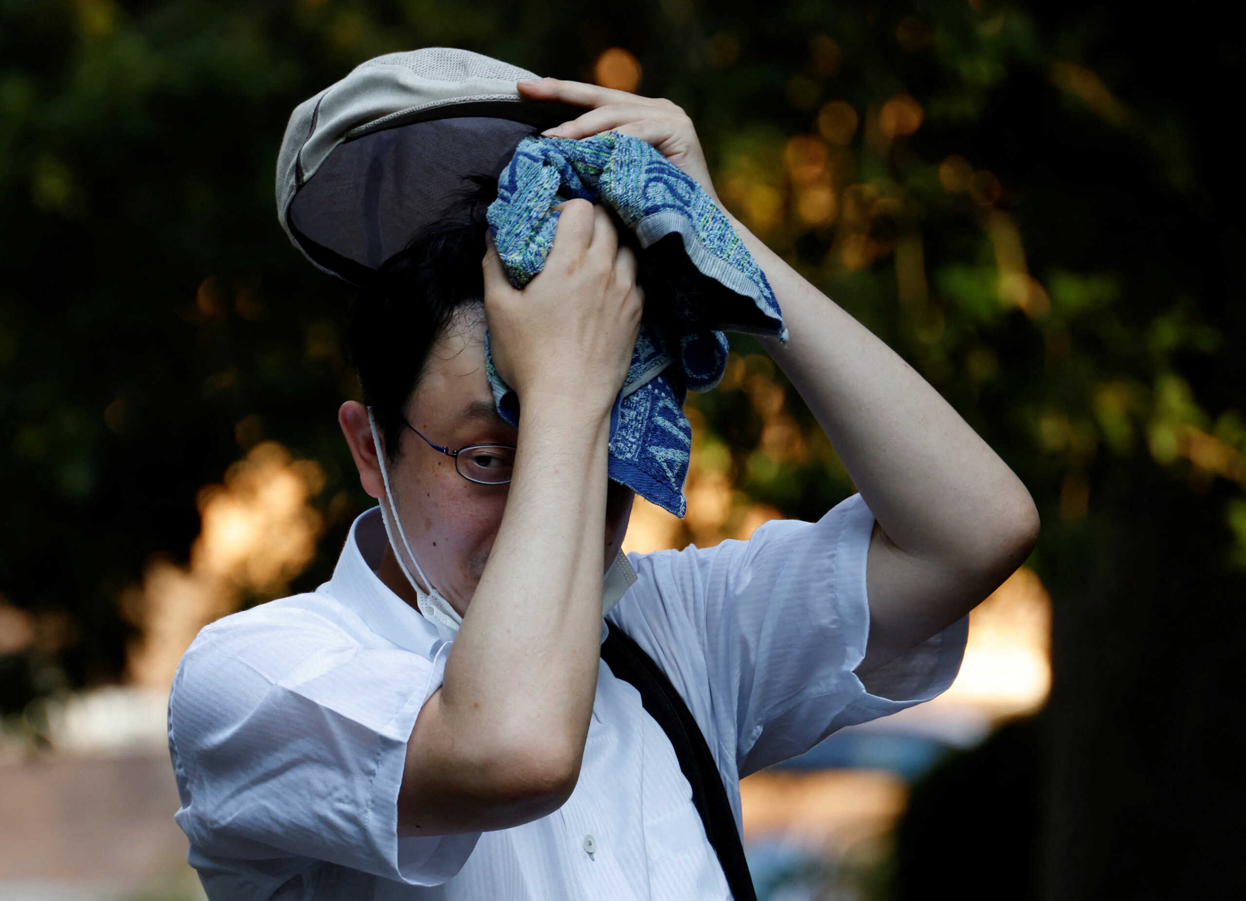 A man wipes off sweat with a towel at a park under the strain of Tokyo's hottest June streak since 1875 in Tokyo, Japan, June 30, 2022. REUTERS