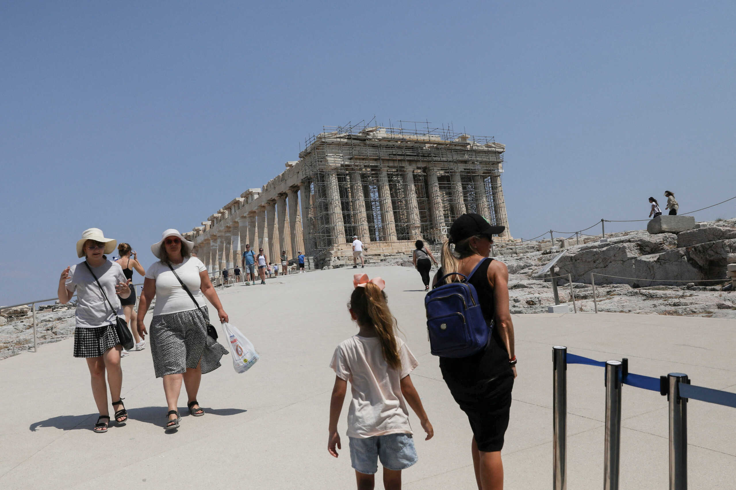 People visit the ancient Parthenon Temple atop the Acropolis hill archaeological site during a heatwave in Athens, Greece, July 25, 2022. REUTERS