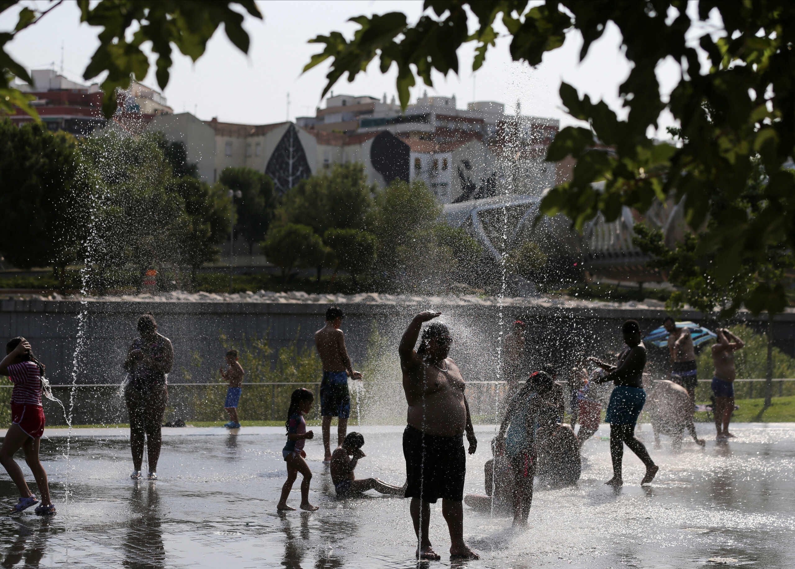People cool off at a fountain in Madrid Rio Park during the second heatwave of the year in Madrid, Spain, July 14, 2022. REUTERS
