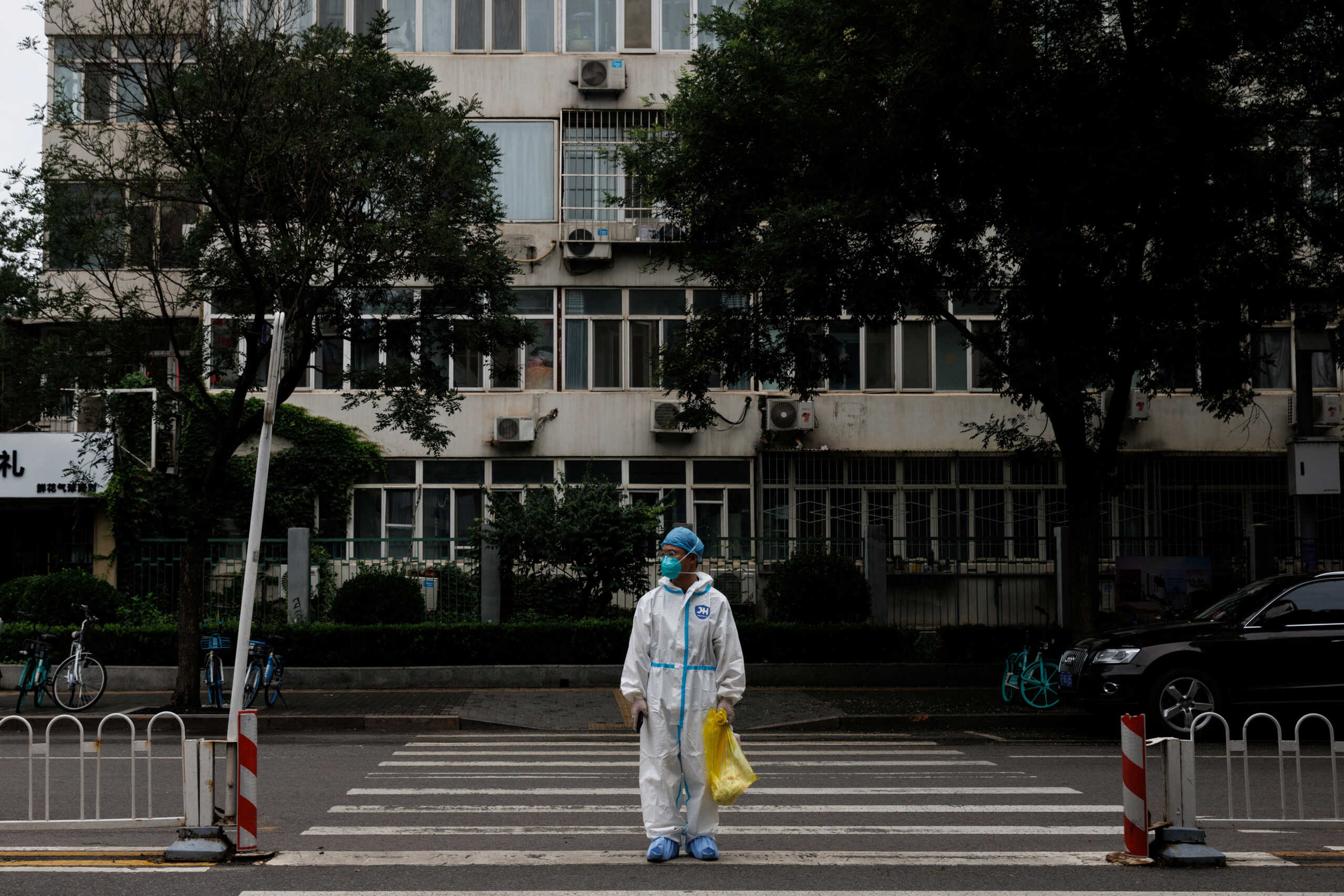 Medical worker in a protective suit crosses a street following a coronavirus disease (COVID-19) outbreak in Beijing, China, July 6, 2022. REUTERS