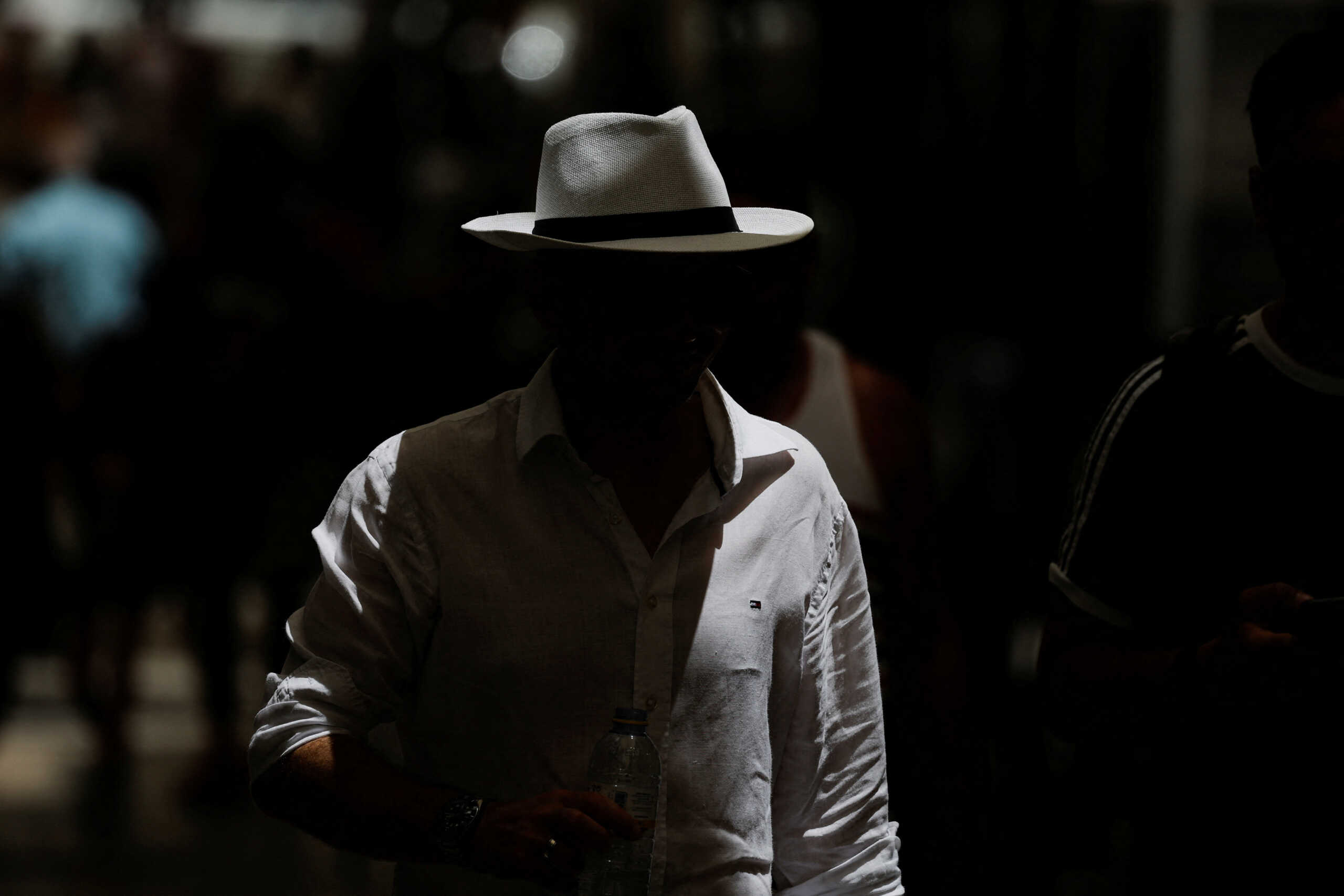 A tourist uses a hat to protect himself from the sun as he walks in a street, as a geomagnetic storm is expected to reach the Earth on Thursday, according to forecasts by the U.S. Office of Oceanic and Atmospheric Administration, in Ronda, Spain July 21, 2022.   REUTERS