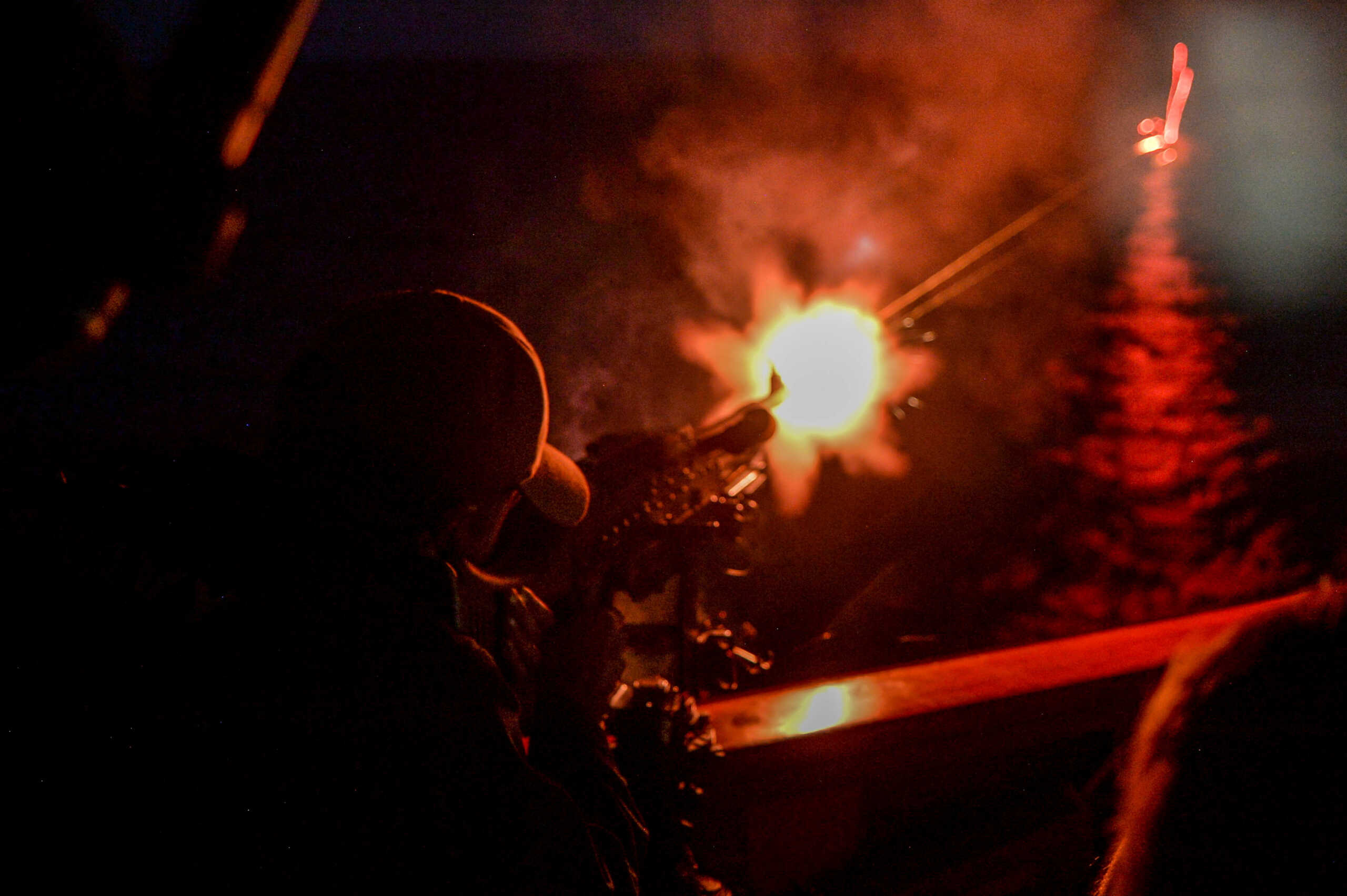 FILE PHOTO: Gunners Mate 2nd Class Austin Brodhacker shoots an M240B machine gun at a killer-tomato target from the bridge wing aboard guided-missile destroyer USS Jason Dunham (DDG 109) during a 60 nations International Maritime Exercise