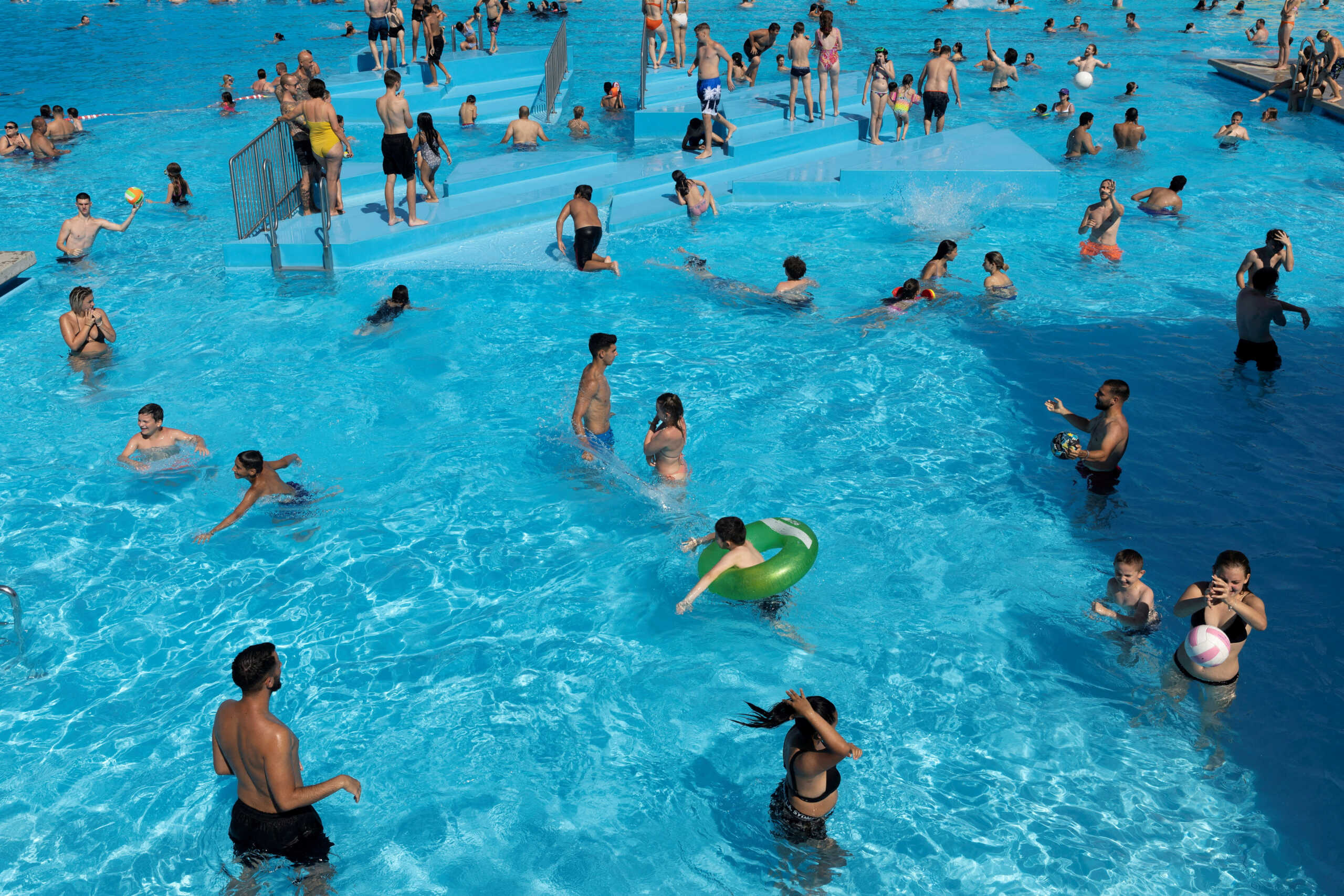 People cool off from the heat in the public pool Schafbergbad in Vienna, Austria, July 20,2022. REUTERS