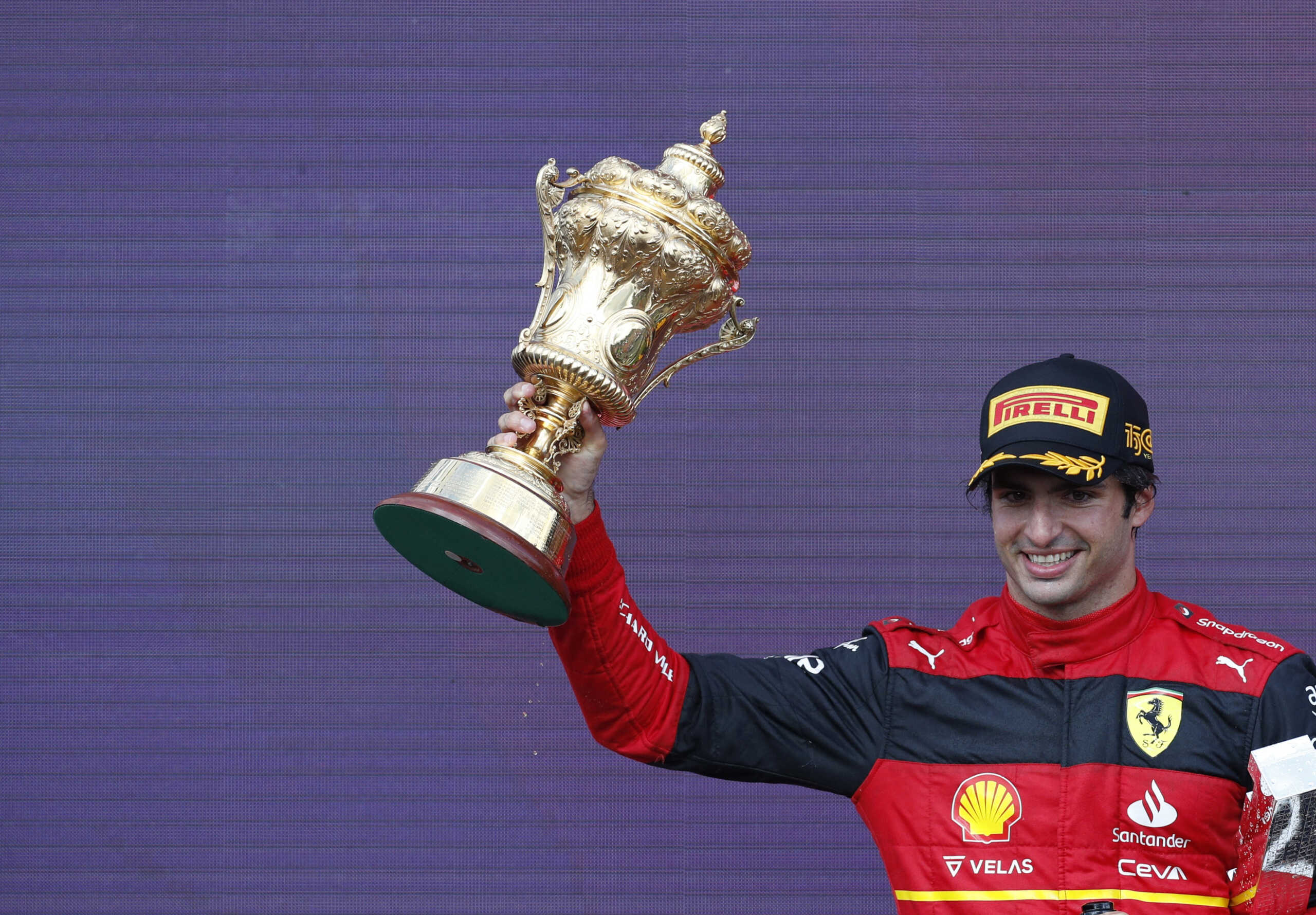 Formula One F1 - British Grand Prix - Silverstone Circuit, Silverstone, Britain - July 3, 2022 Ferrari's Carlos Sainz Jr. celebrates winning the race on the podium with the trophy REUTERS