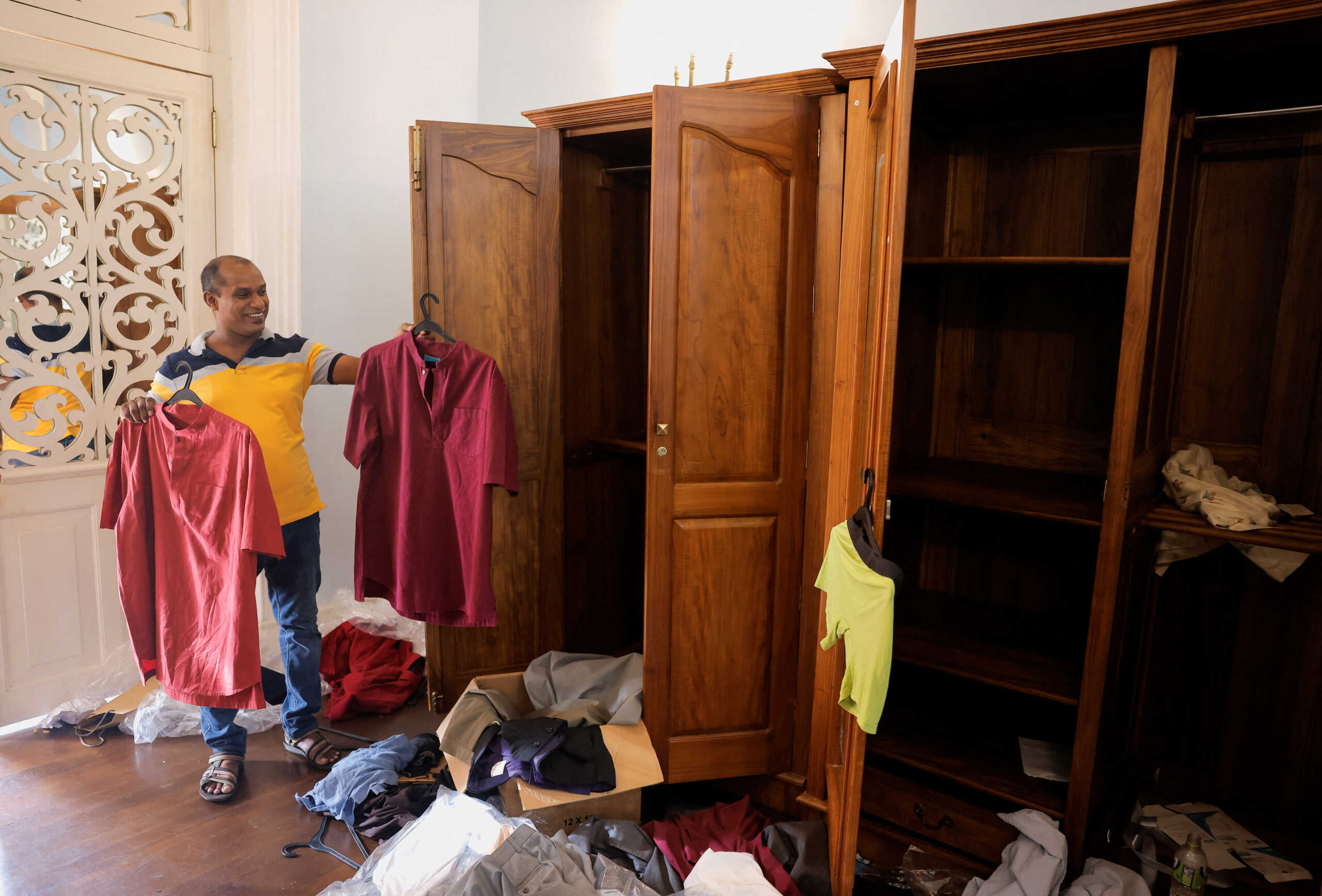A man holds shirts belonging to President Gotabaya Rajapaksa, inside the President's house on the following day after demonstrators entered the building, after President Gotabaya Rajapaksa fled, amid the country's economic crisis, in Colombo, Sri Lanka July 10, 2022. REUTERS